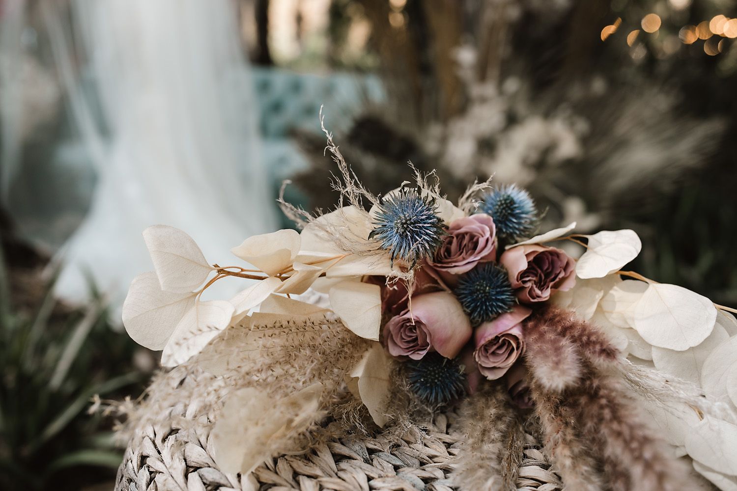 Delicate floral arrangement with muted pink roses and dried elements in vintage style.