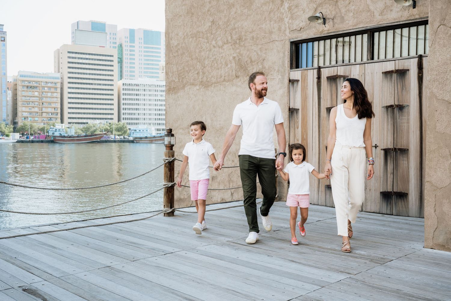 Family walking together through modern urban architecture with concrete walls.