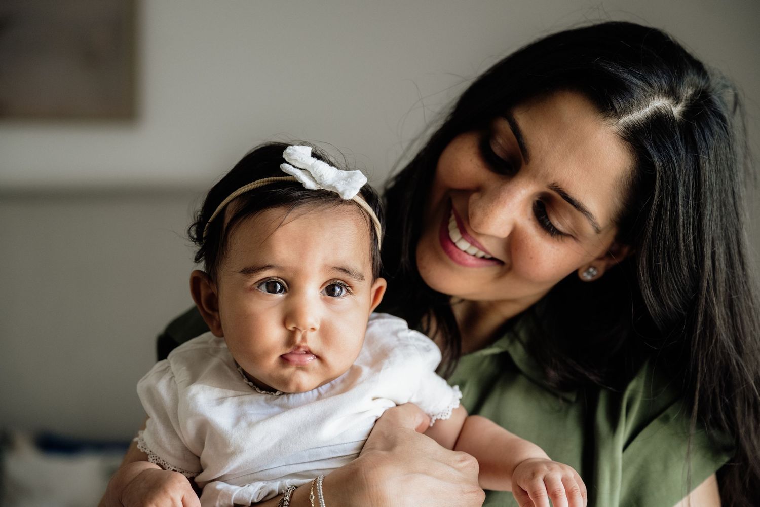 Intimate family moments captured in a series of tender interactions with a baby in white.