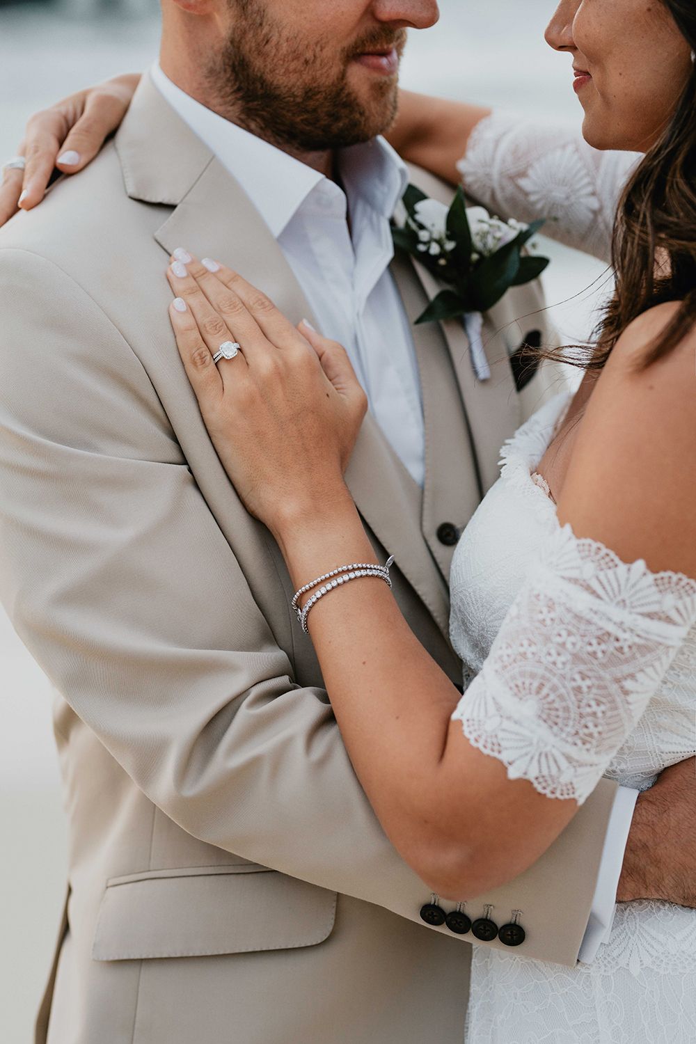 Detail shots of wedding attire including lace dress and tan suit during beach portraits.