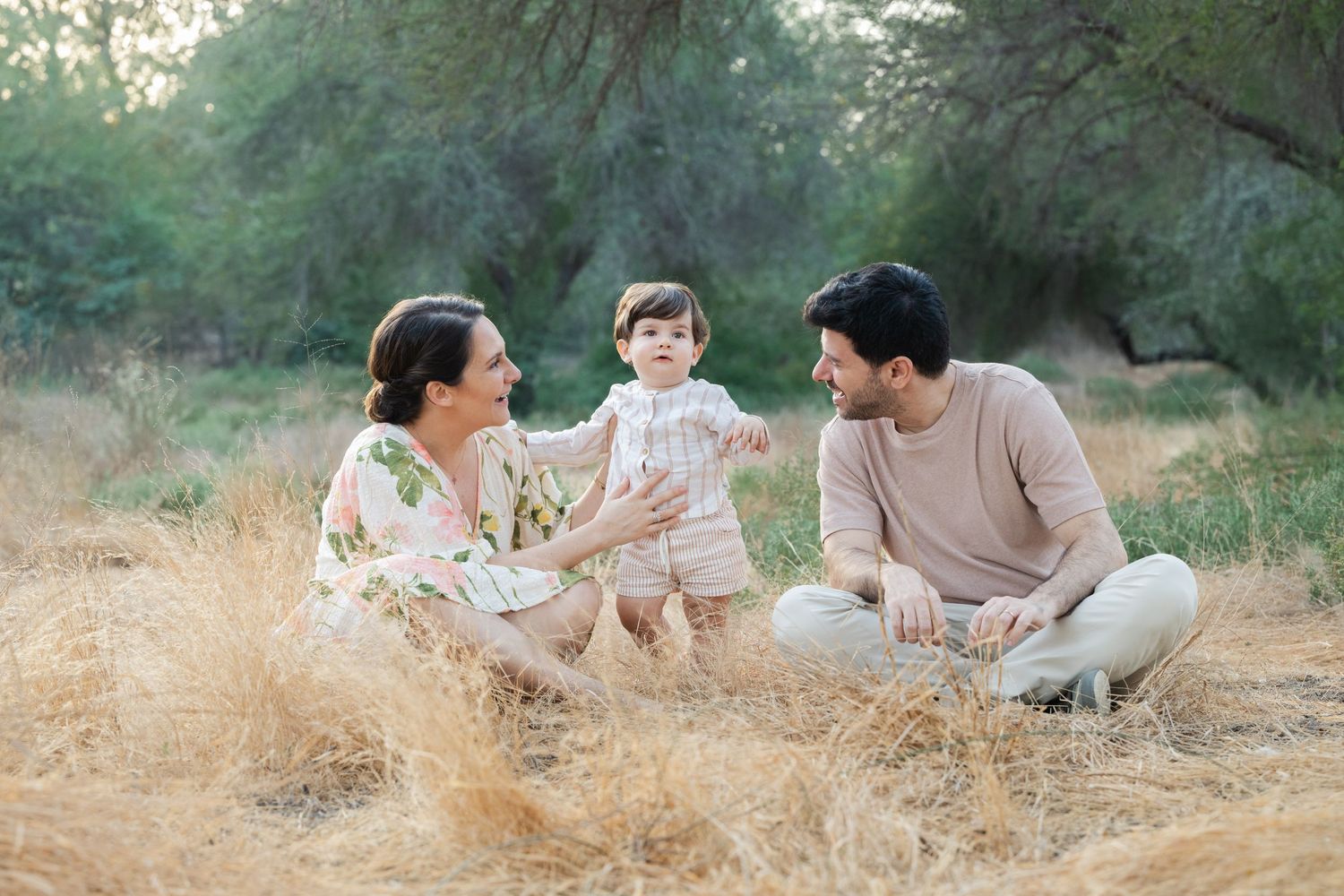 Candid outdoor photography session in golden grass with natural lighting.