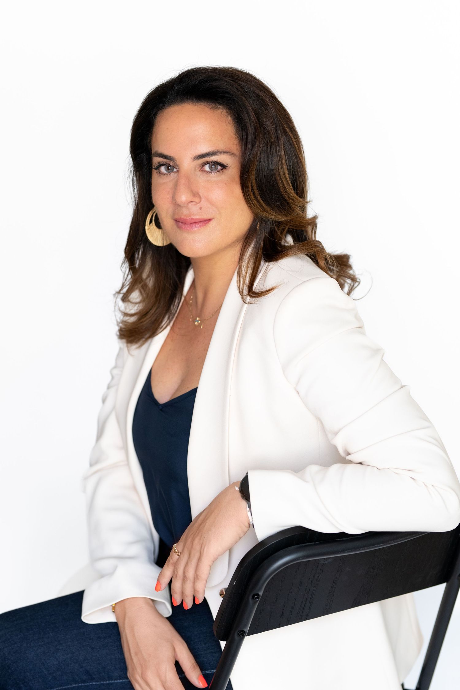 Professional headshot series in white blazer against studio background.