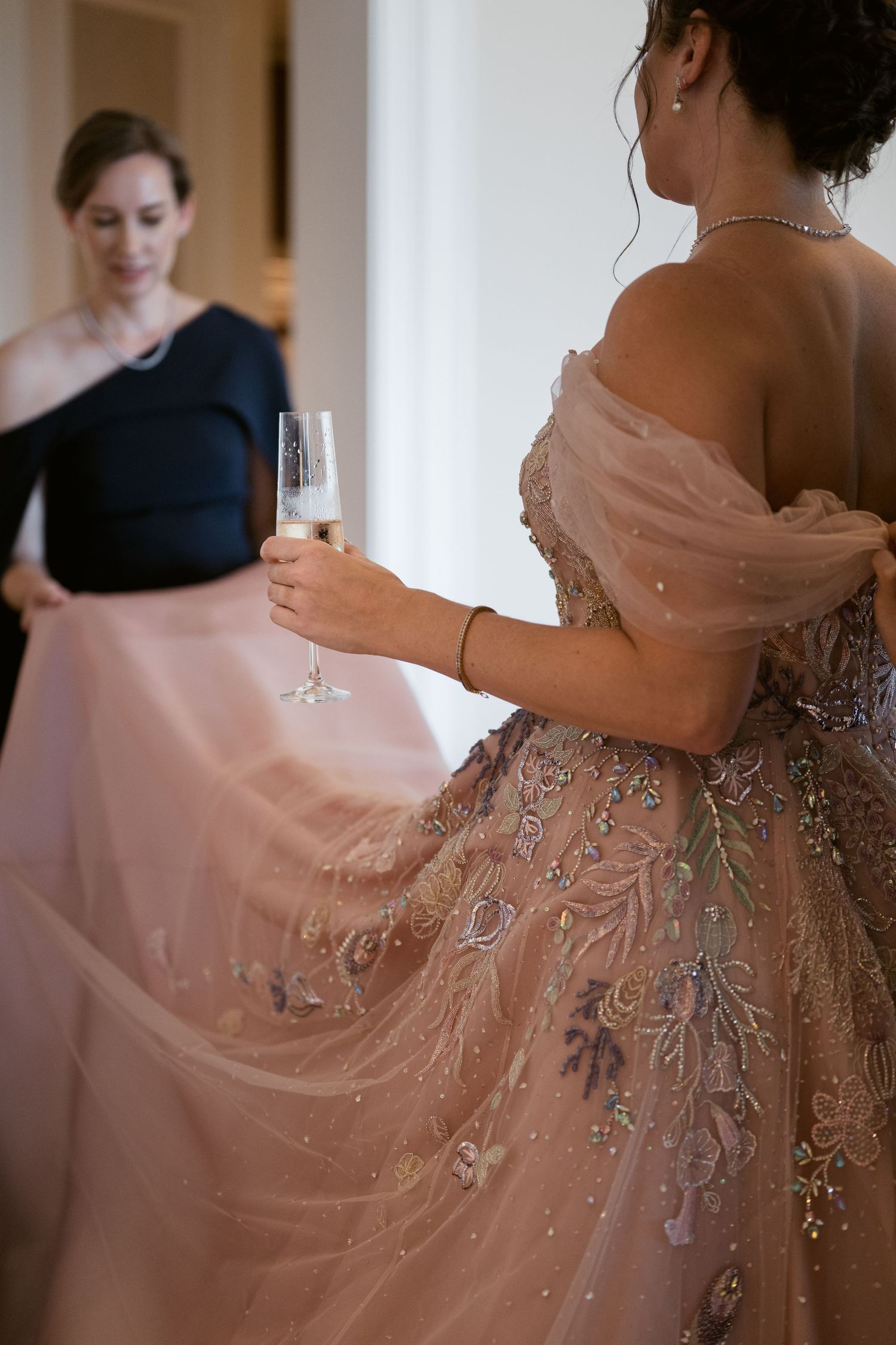 Elegant beaded pink gown with flowing fabric and intricate embellishments captured in natural light.