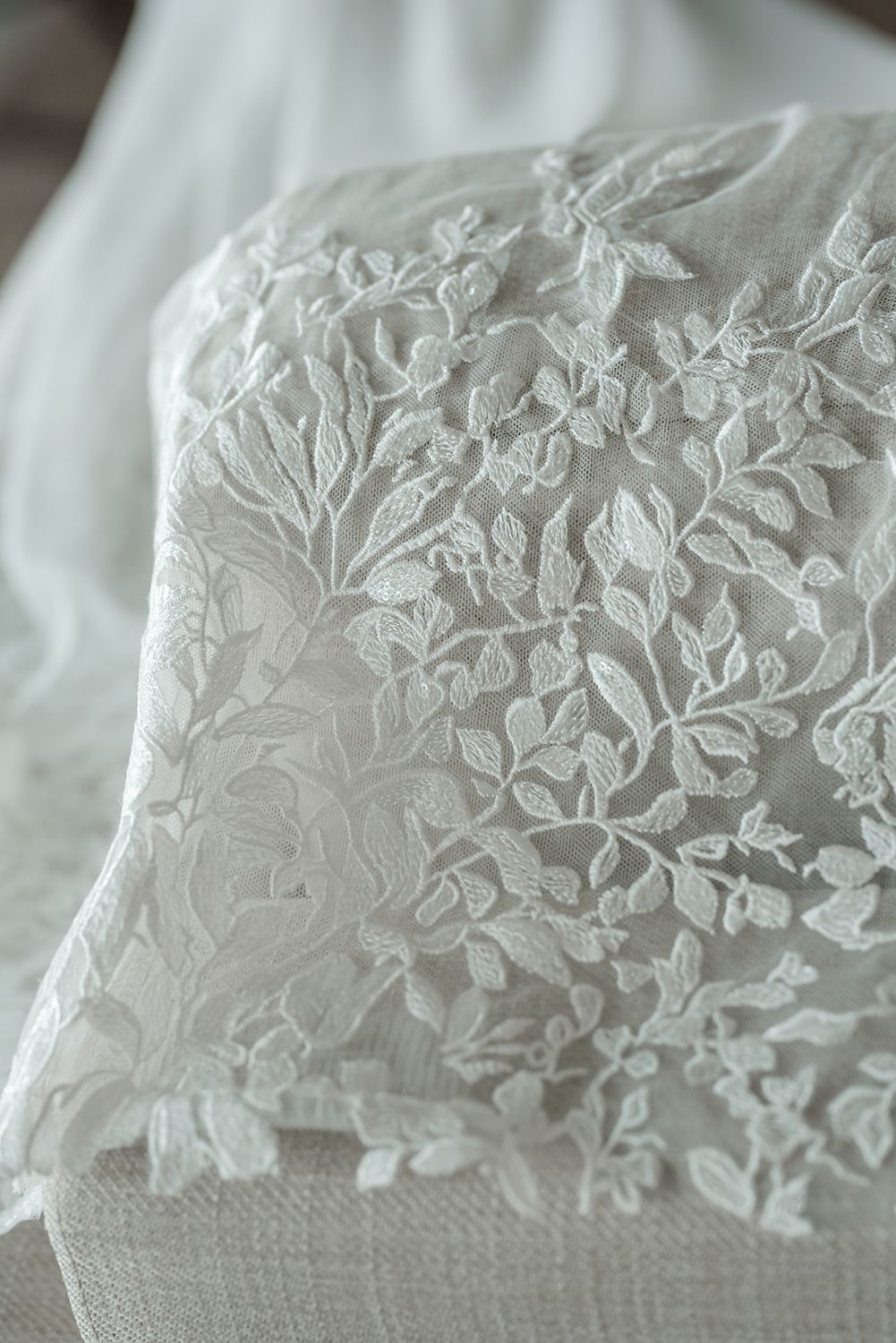 Delicate floral lace pattern detail on white fabric.