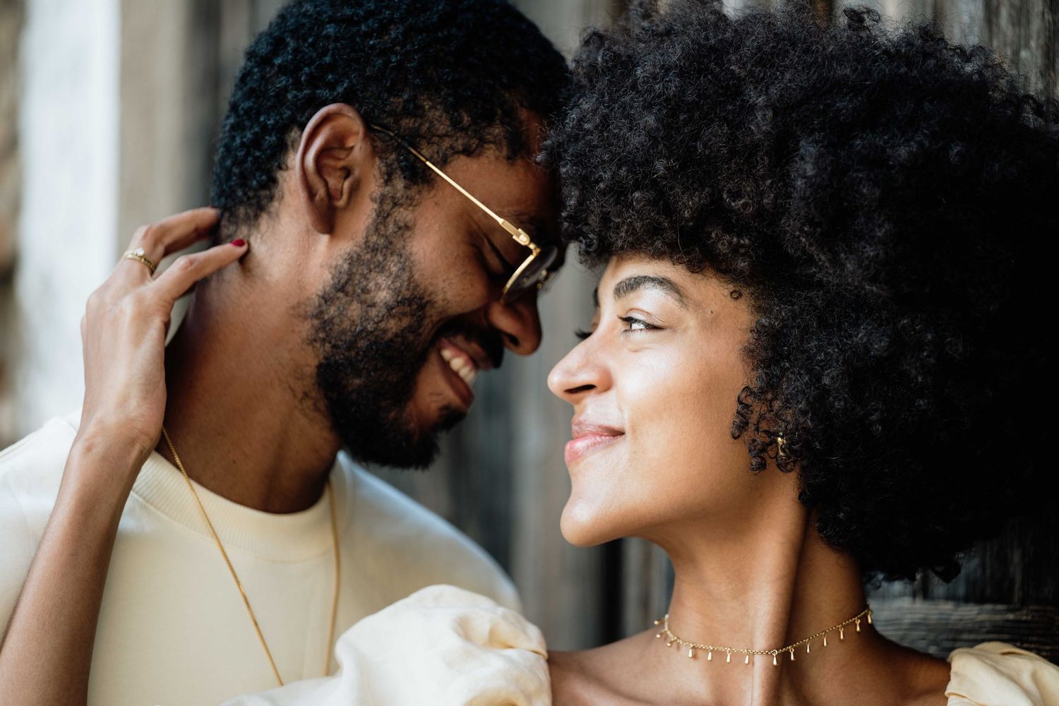 Tender moments captured between a couple in coordinated cream and white outfits.