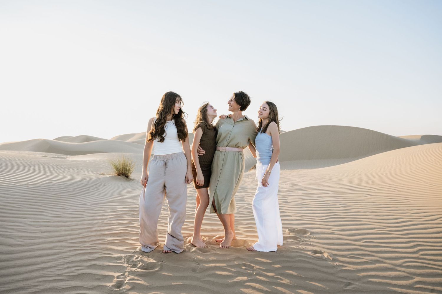 Group enjoying time together on desert sand dunes during photoshoot.