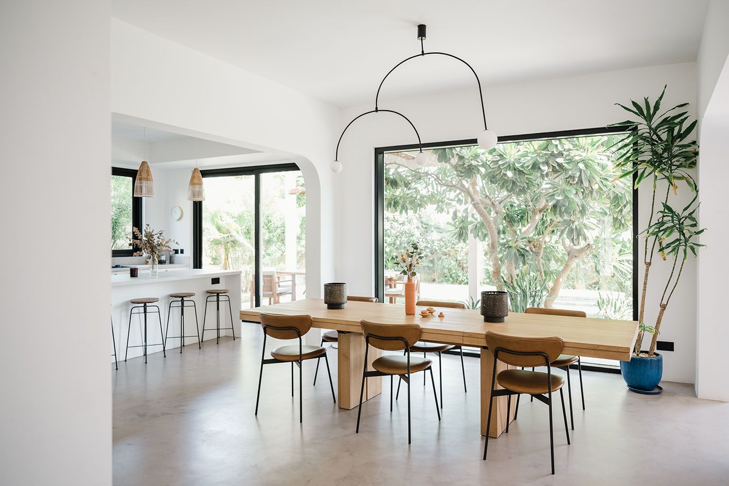 Open concept dining area with wooden furniture and large windows providing natural light.