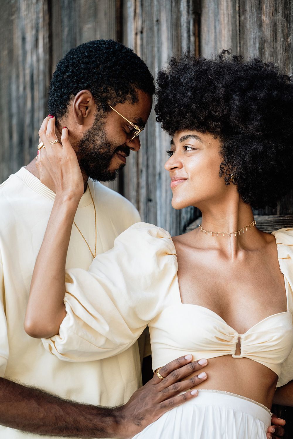 A romantic couple in white attire share intimate moments in a series of connected photos against a rustic backdrop.