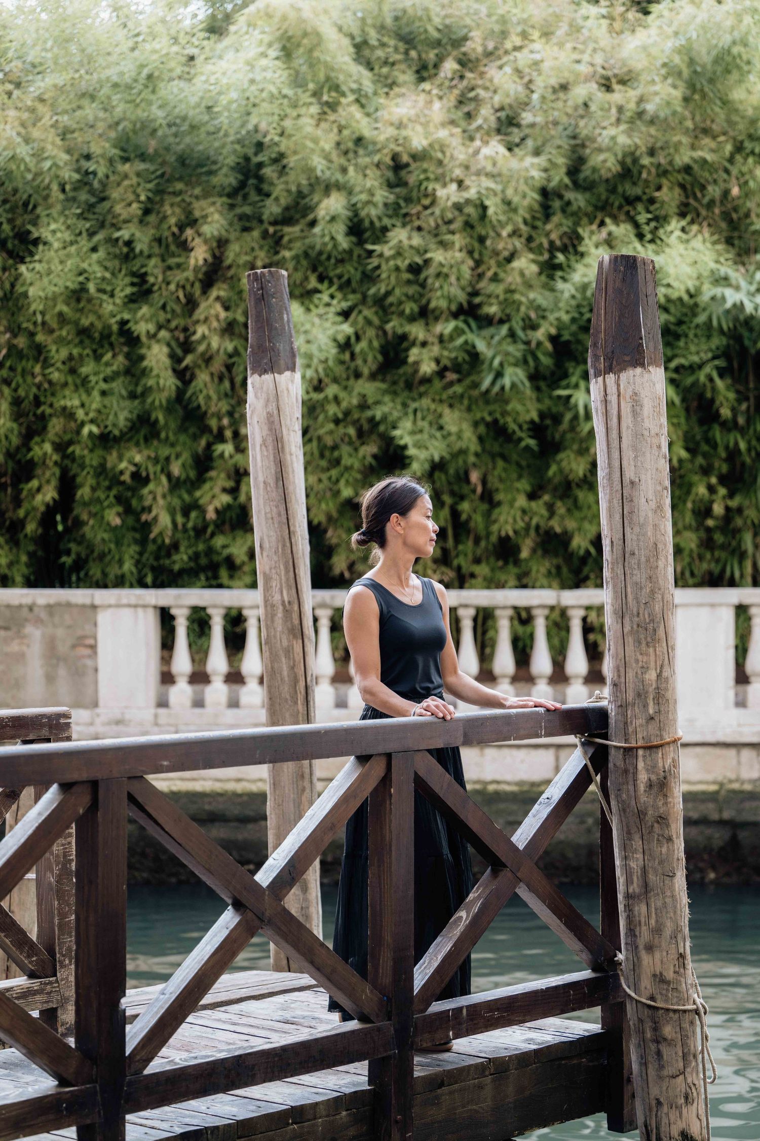 Wooden dock with rustic posts and crossbeams overlooks a tranquil waterway.