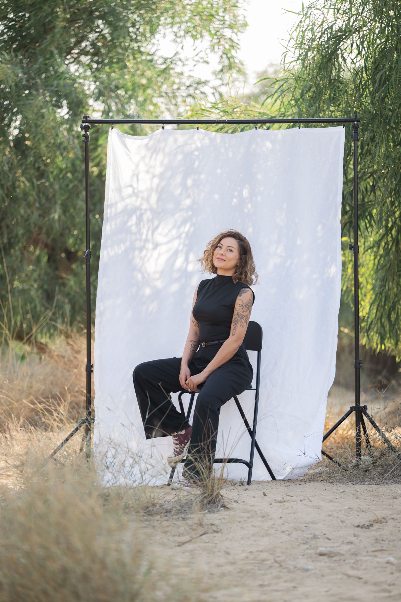 A sequence of artistic outdoor portrait shots against a white backdrop with tall grass and trees in the background.