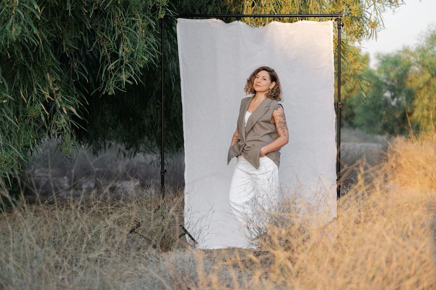 Outdoor portrait session with white backdrop against natural golden field setting.