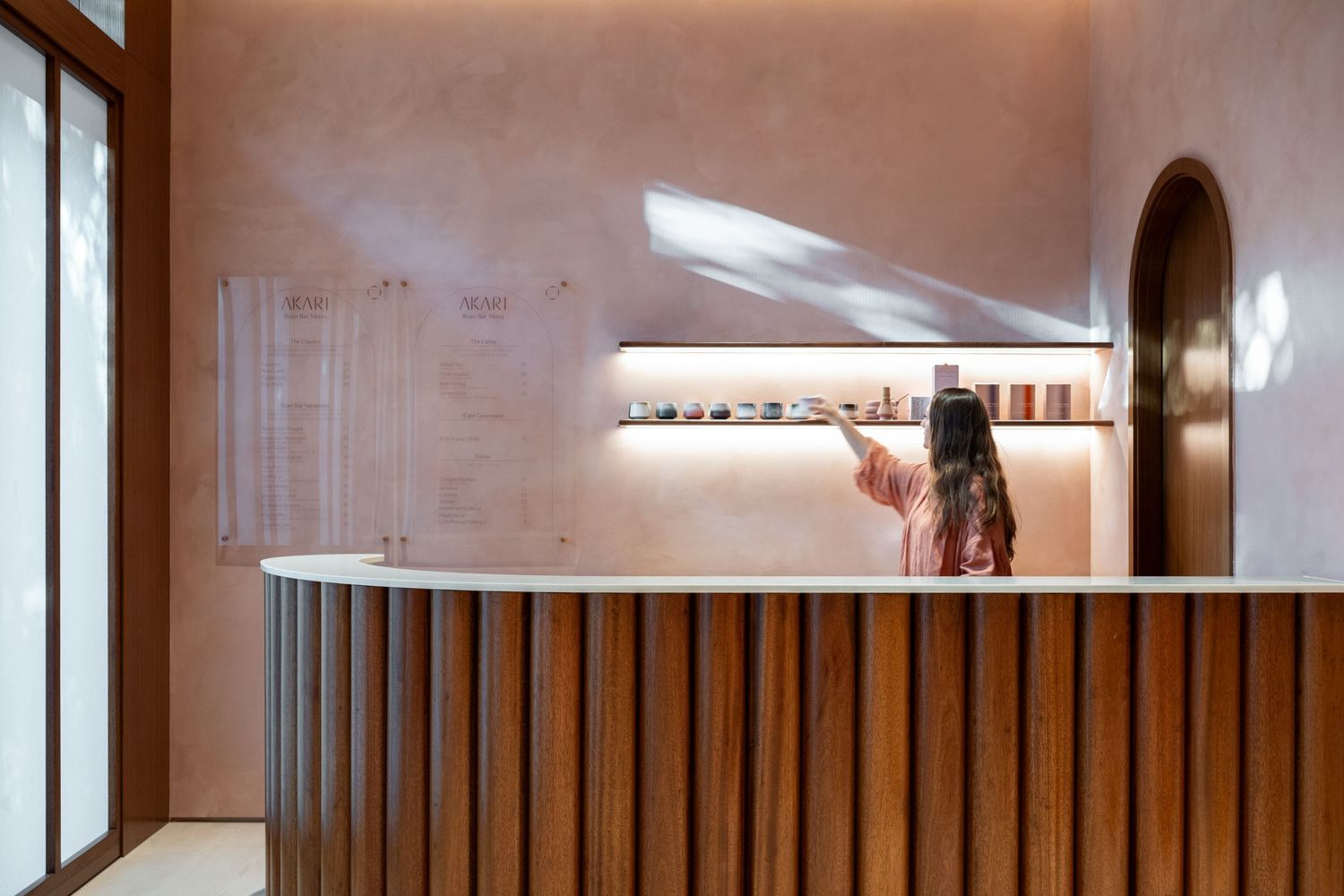 Modern interior hallway with wooden slat details and ambient lighting creating depth and warmth.