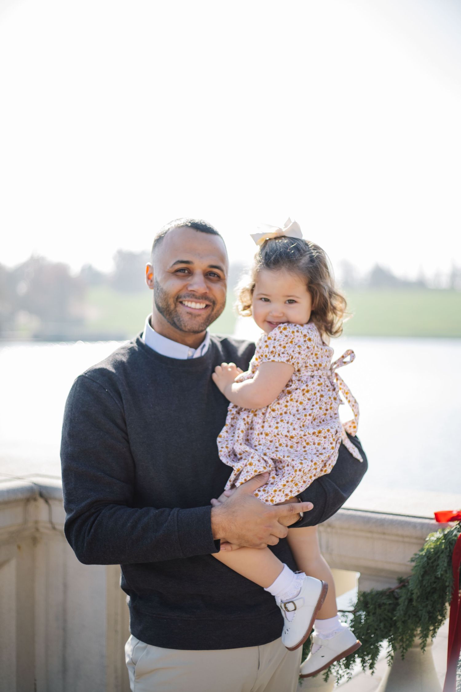 A joyful family moment shared on a stone balcony with holiday decorations.