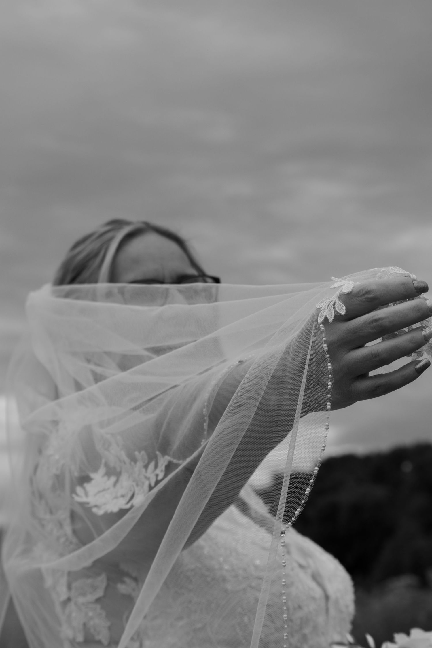 Artistic black and white photo showing flowing wedding veil details.