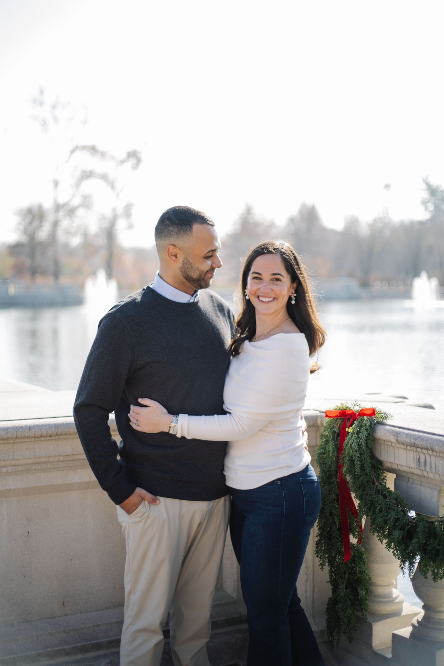Casual family portraits taken outdoors with festive holiday greenery decorations.