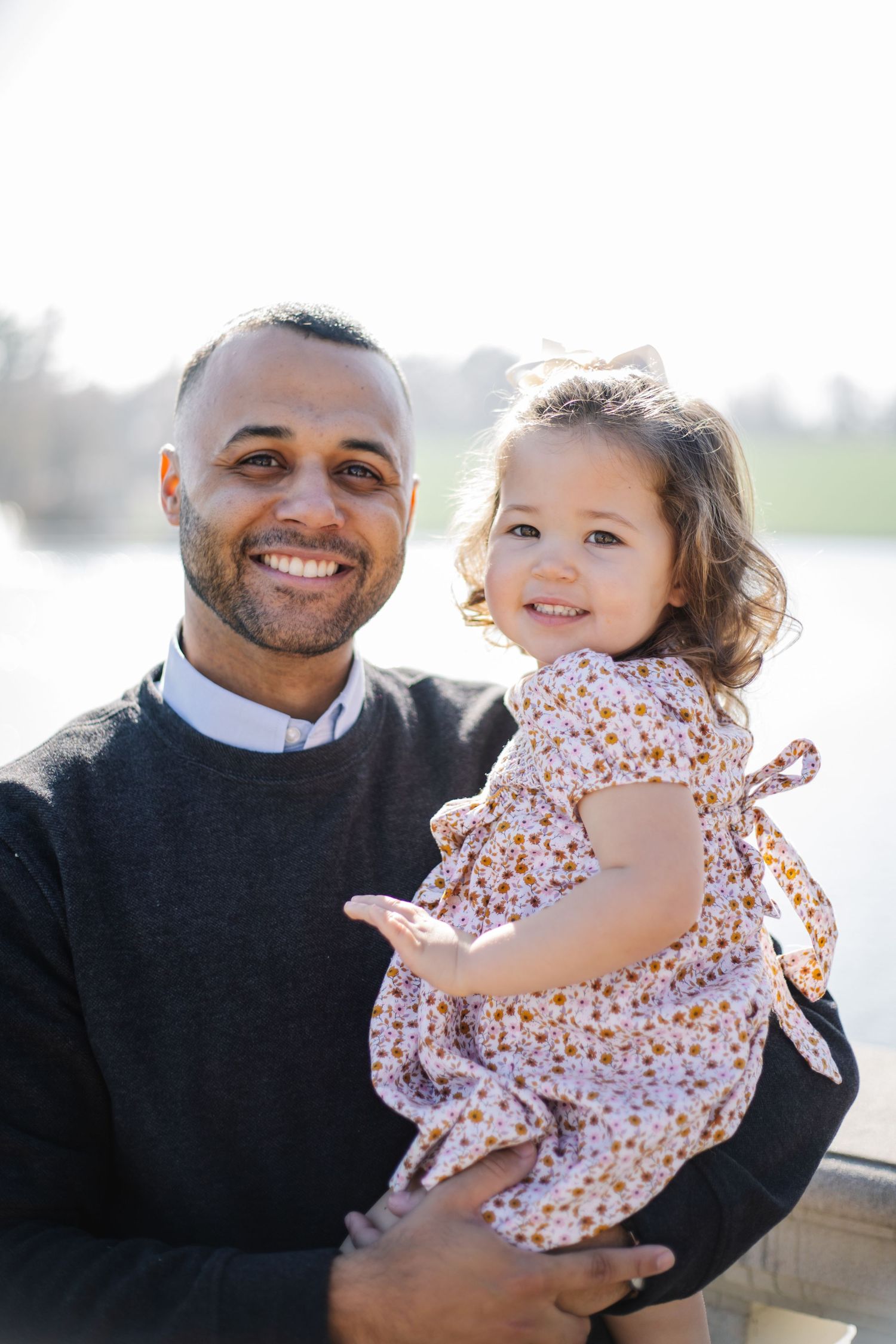 Candid family photos taken outdoors against a waterfront backdrop with festive decorations.