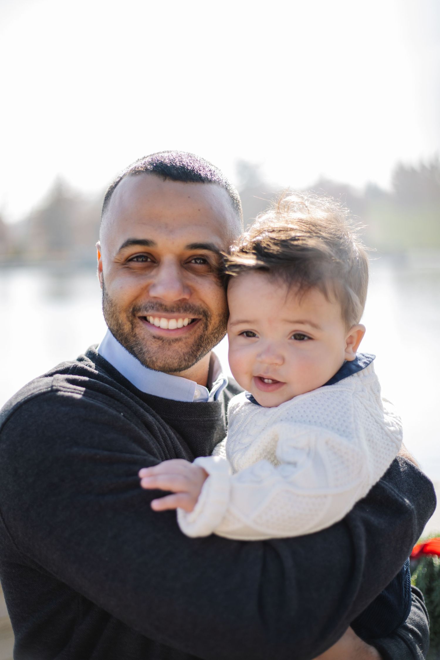 A heartwarming outdoor family portrait showing joyful expressions and tender embraces.