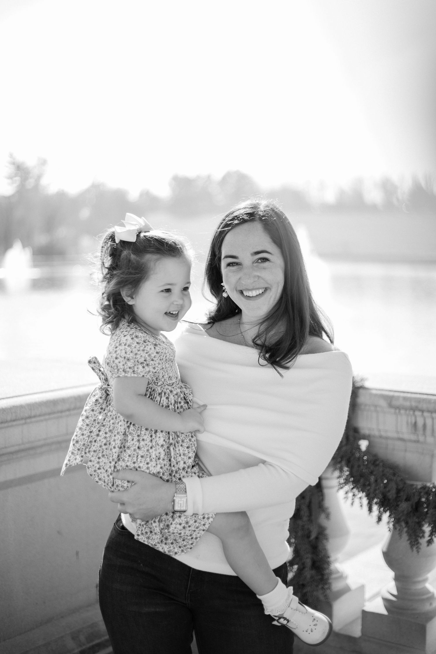 A joyful black and white series of candid moments captured between a parent and child on a stone balcony.