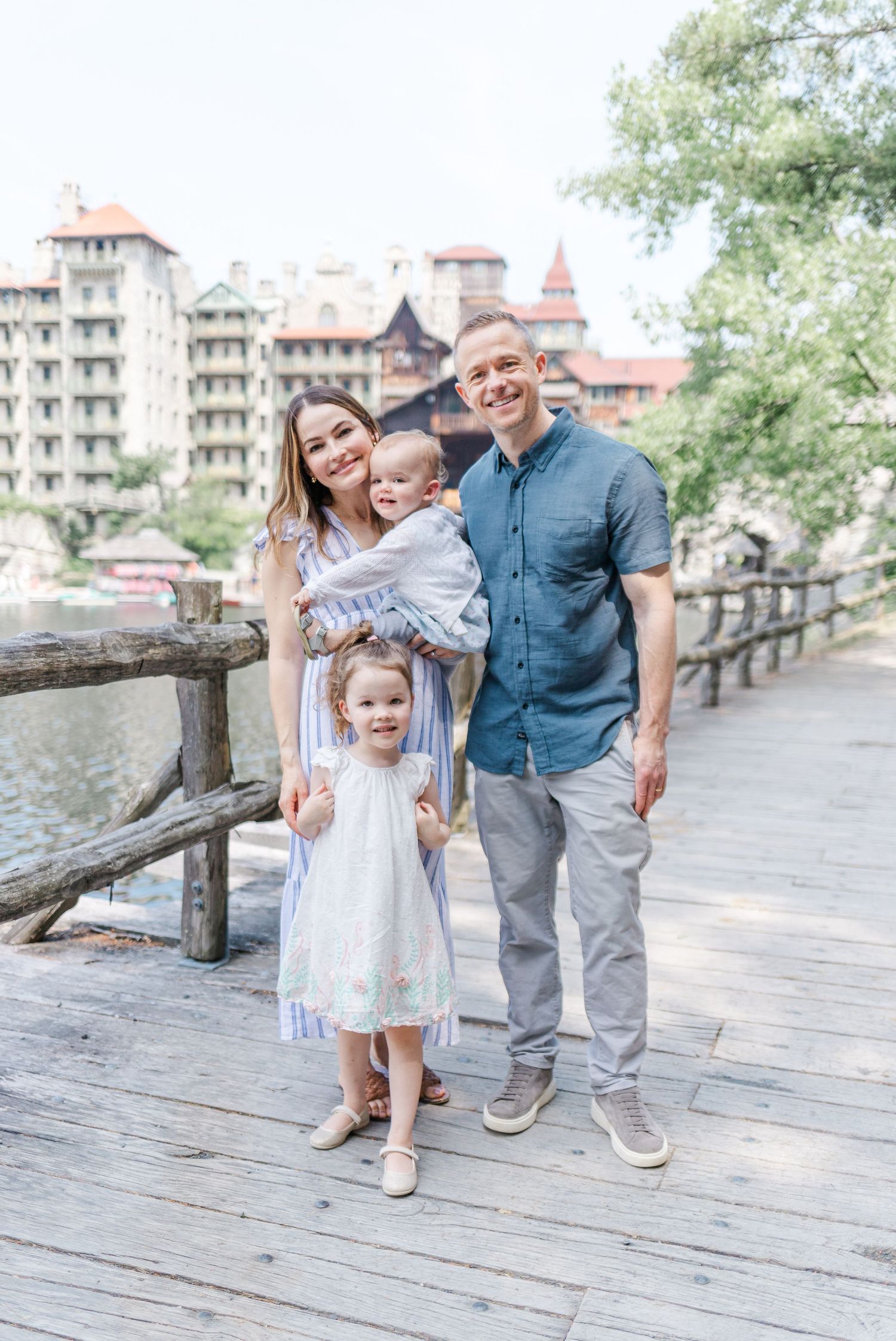 Family smiling in front of Mounk Mountain House during a family session in New Paltz, NY.