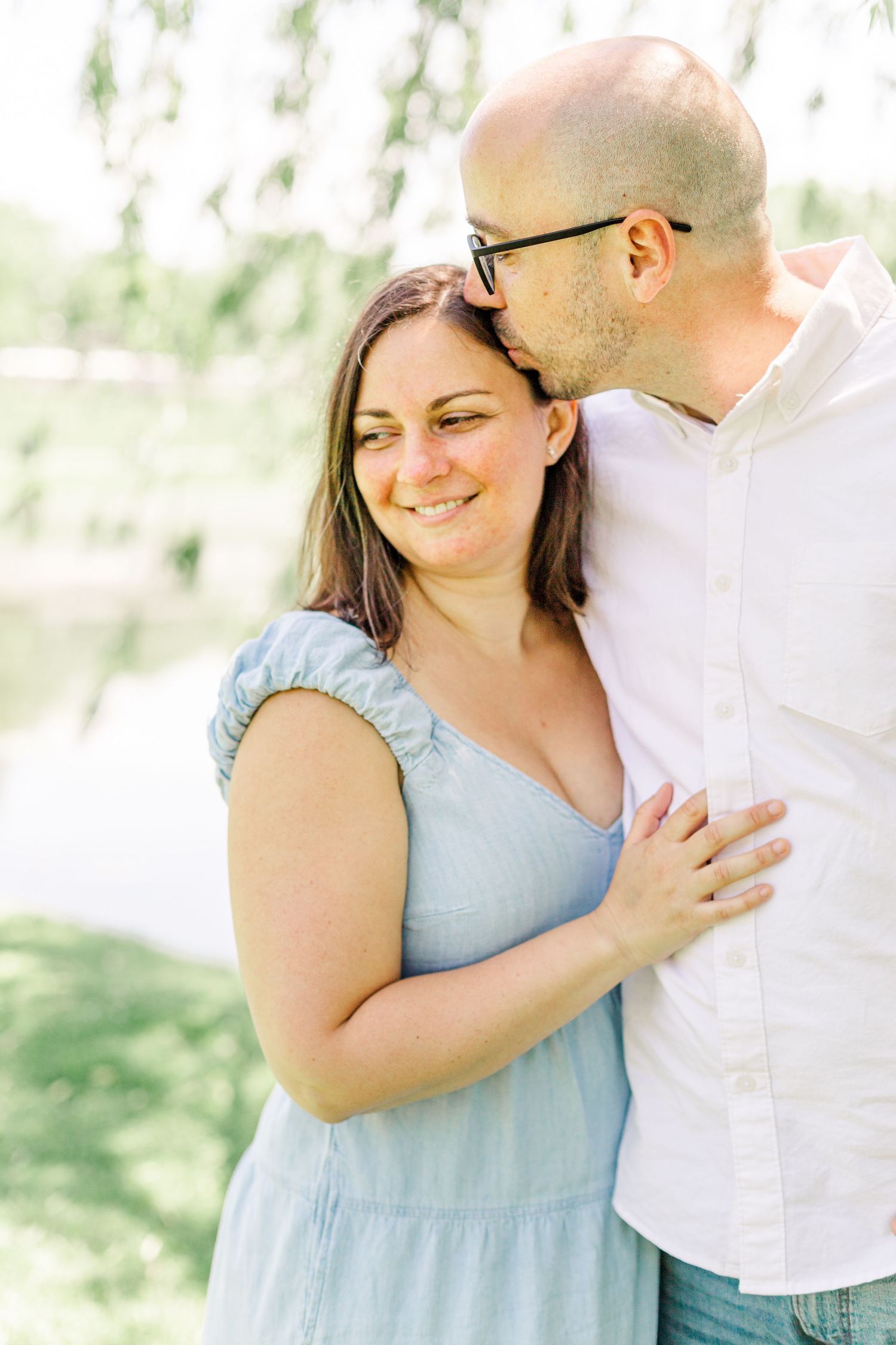 couple wearing blue and white clothes hugging during a family session in the hudson Valley of NY