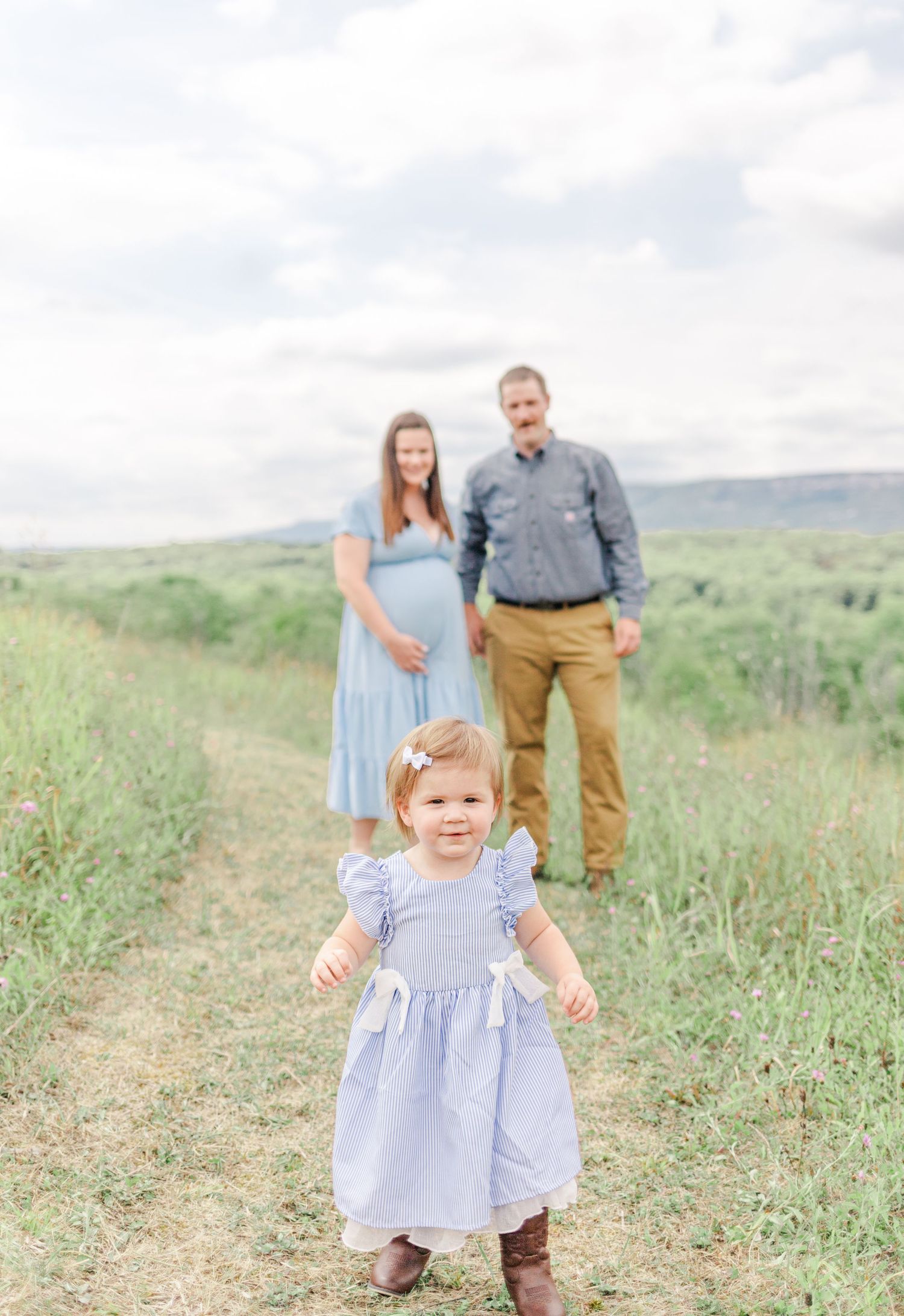 Family smiling in front of Mohonk mountains with family dressed in blue and tan during a family session in the hudson Valley of NY