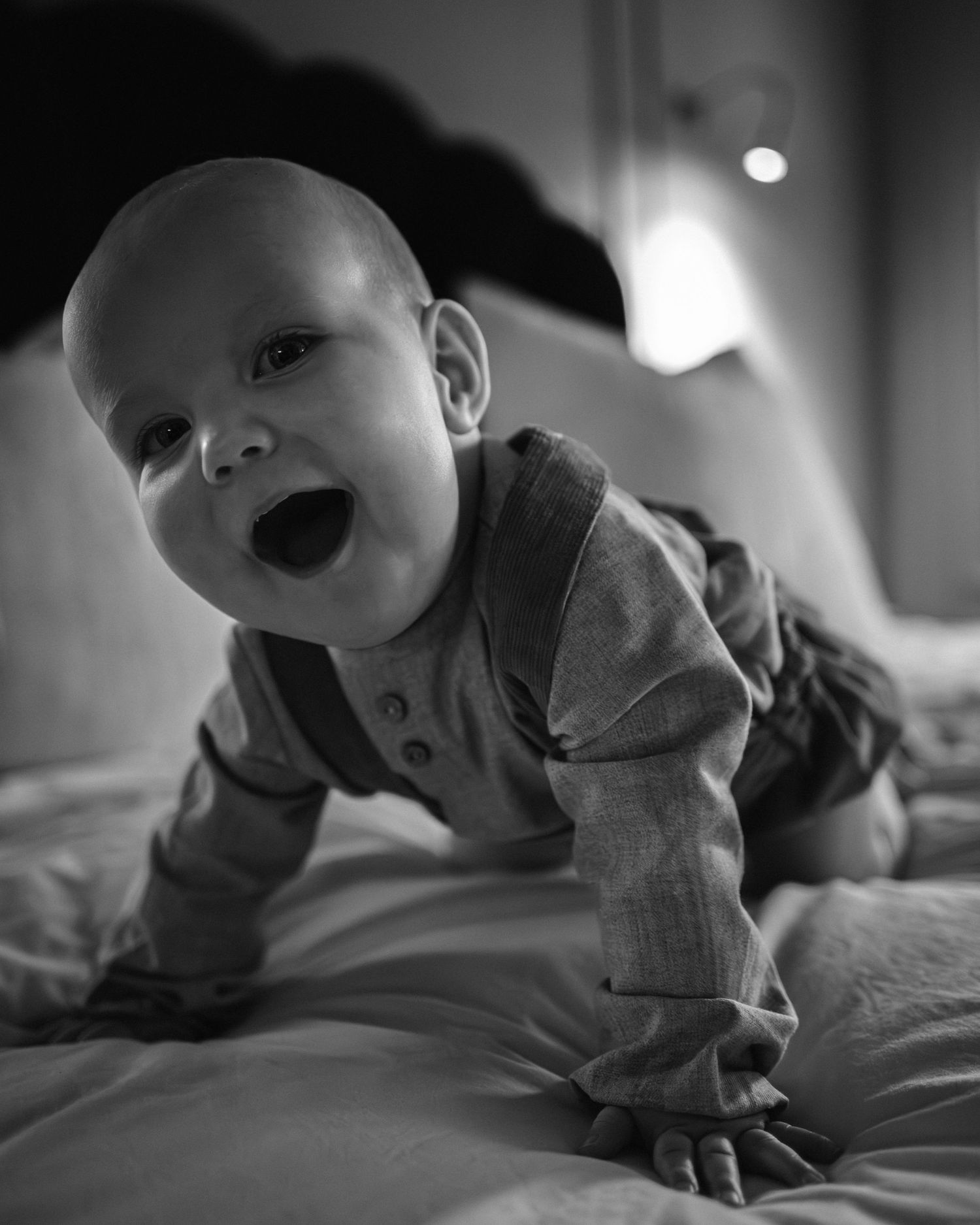 Series of black and white images showing a baby lying on soft bedding.