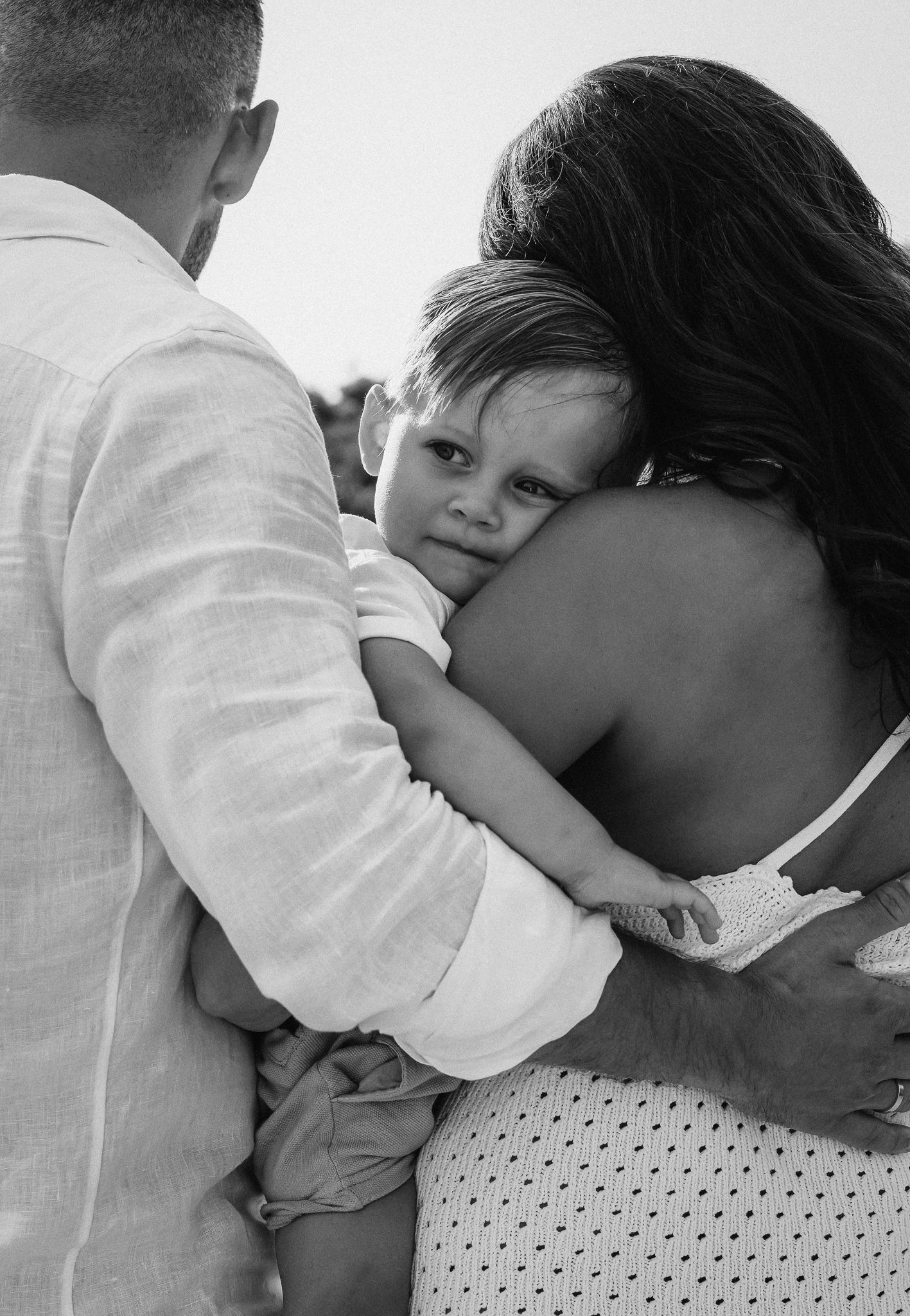 Intimate black and white portrait showing tender family embrace.