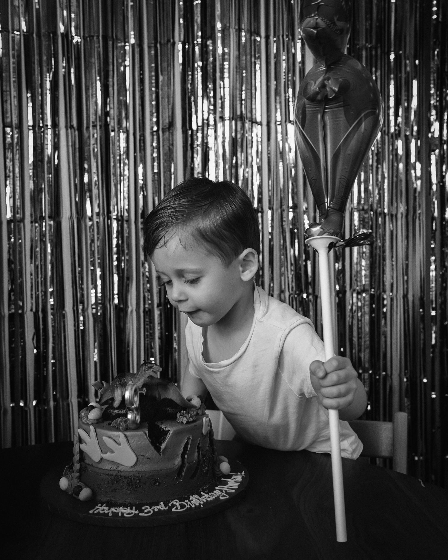 Black and white photos of someone blowing bubbles against a shimmering curtain background.