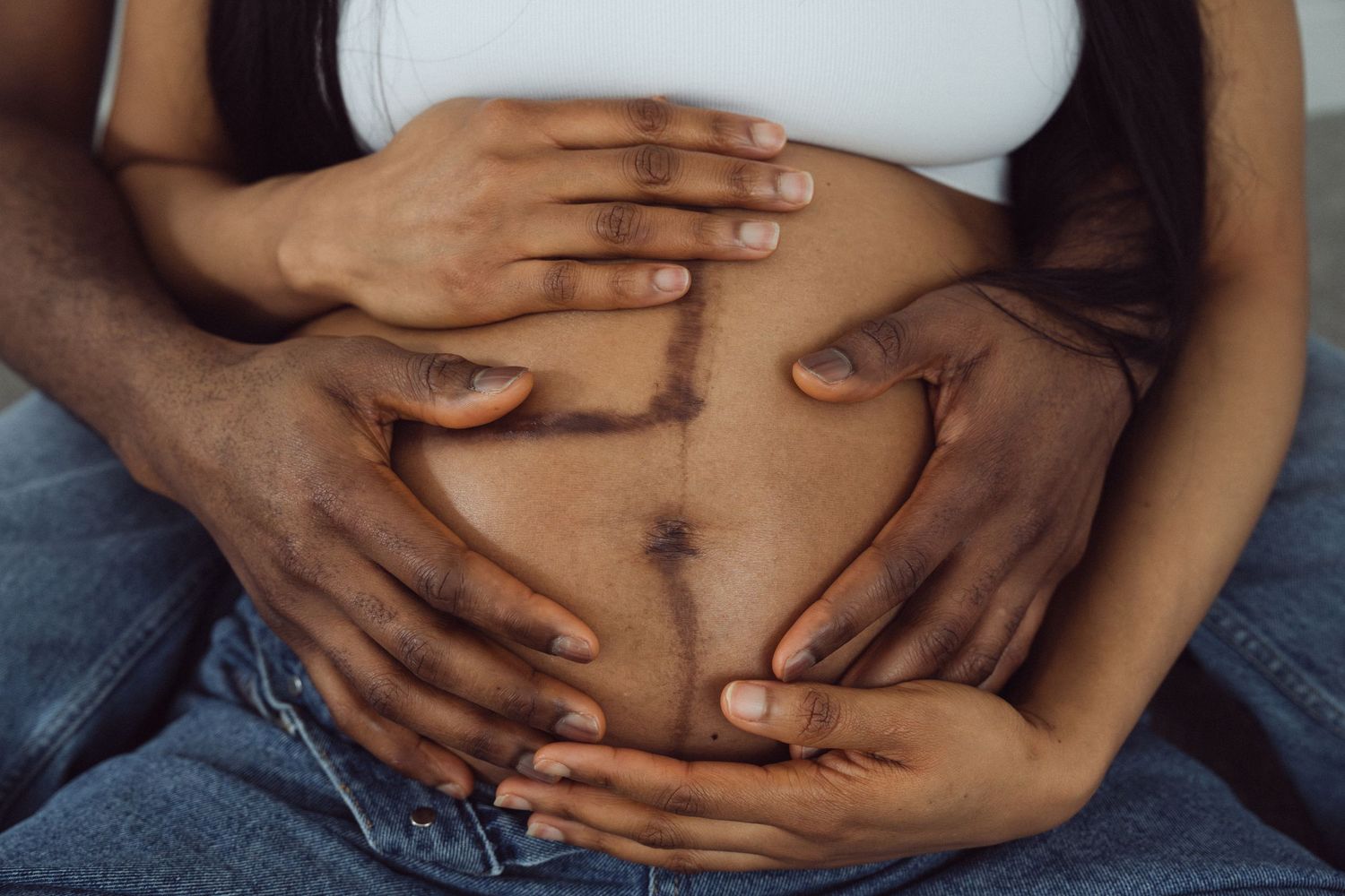Intimate maternity portrait, couple's hands on baby bump showing linea nigra | London maternity photographer by Inga Franlund