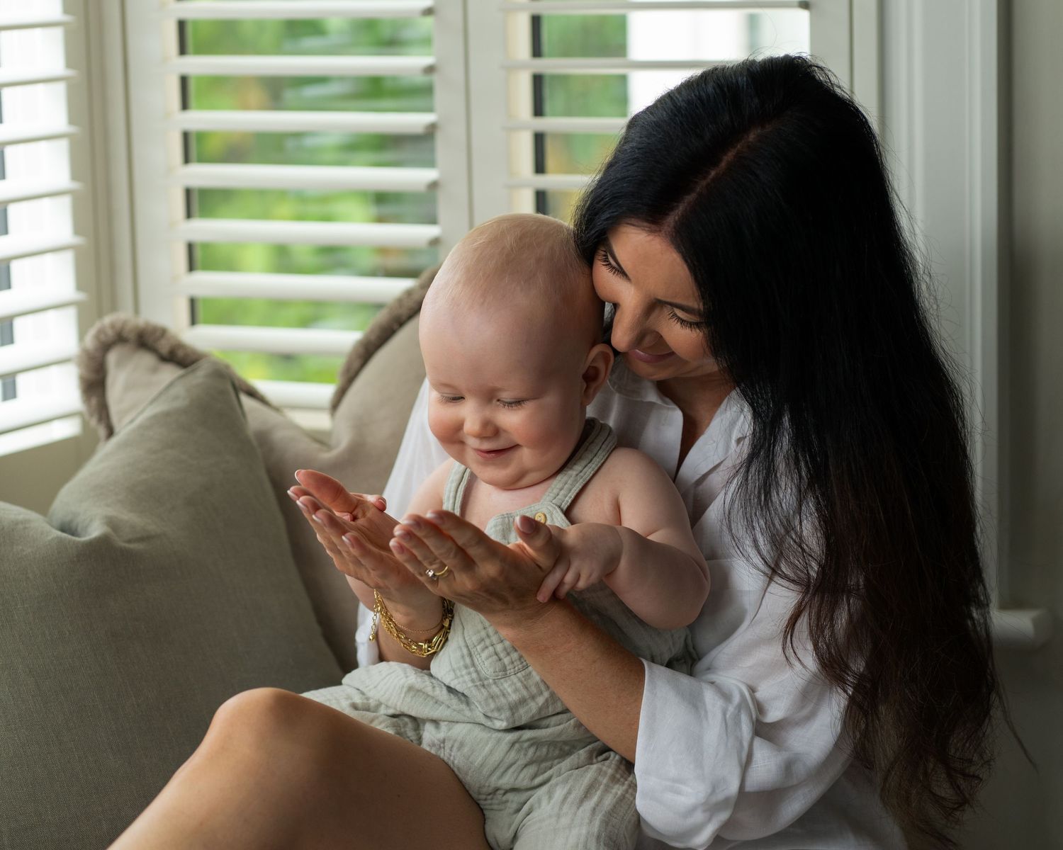 A sweet bonding moment between parent and infant by a window with natural light.