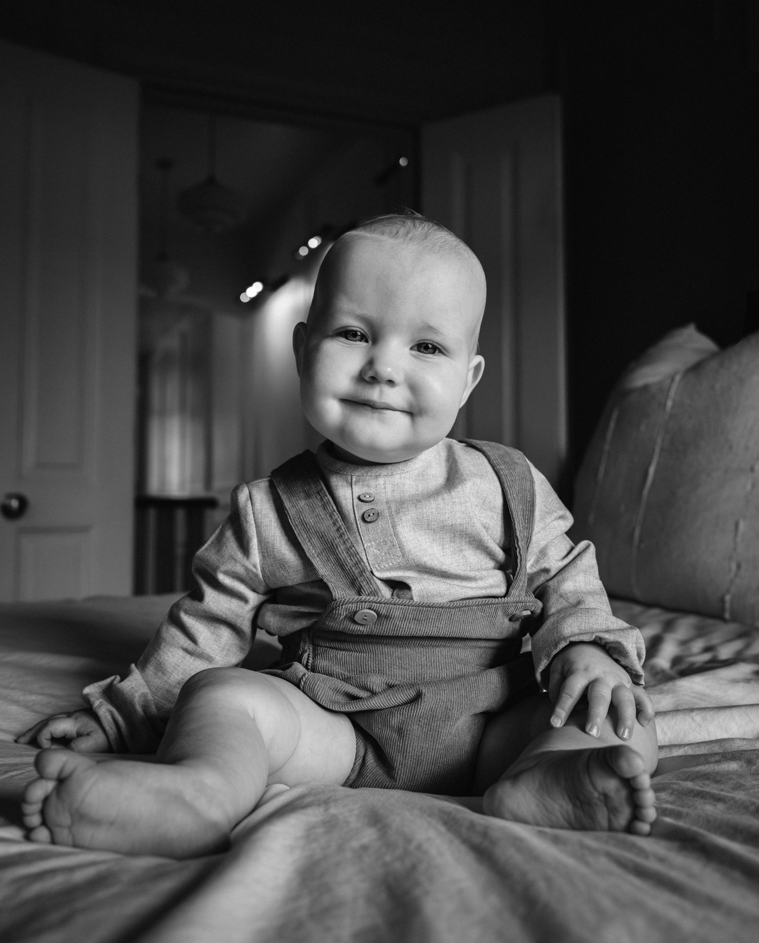 Black and white photo sequence of a baby sitting on textured bedding.