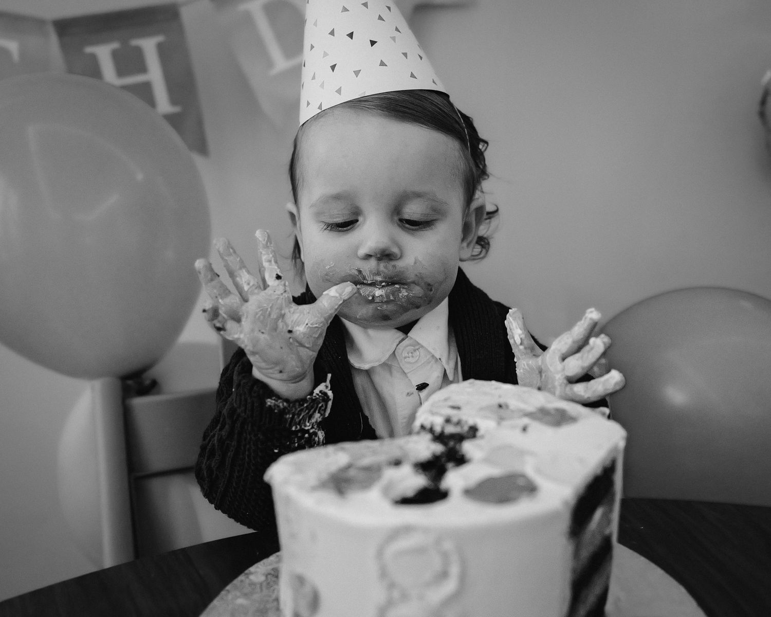 Black and white photos of a birthday celebration with cake and messy frosting fun.