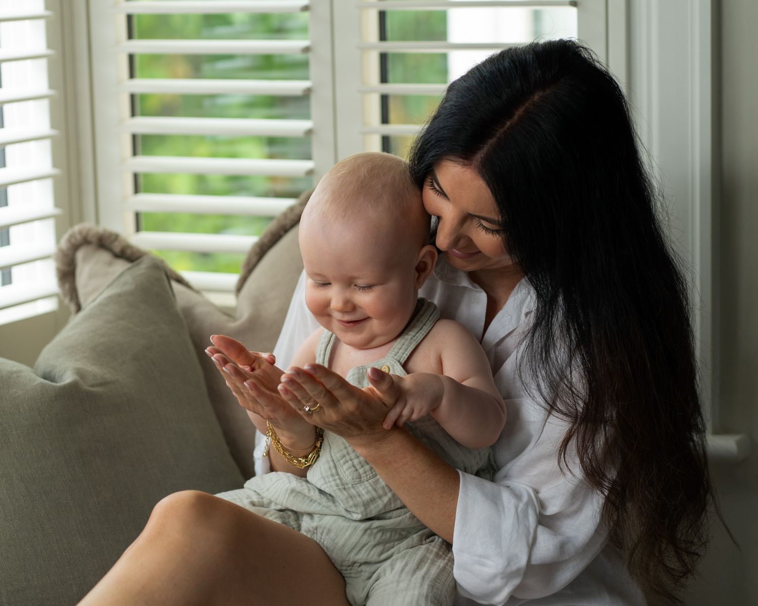 A series of intimate moments between parent and infant captured in soft natural window light.