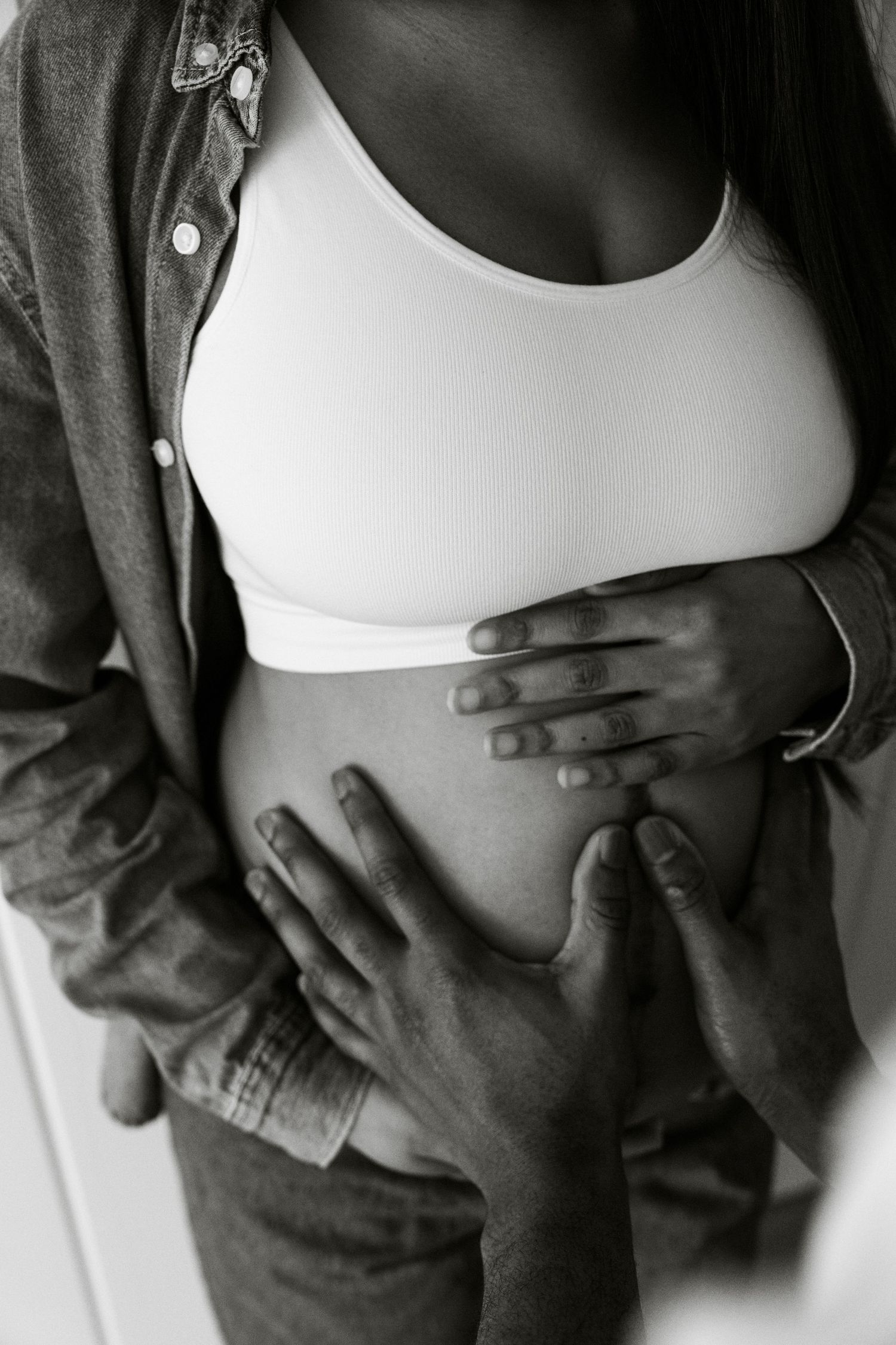 Black and white maternity portrait, partner's hands cradling baby bump | Maternity photographer in London by Inga Franlund
