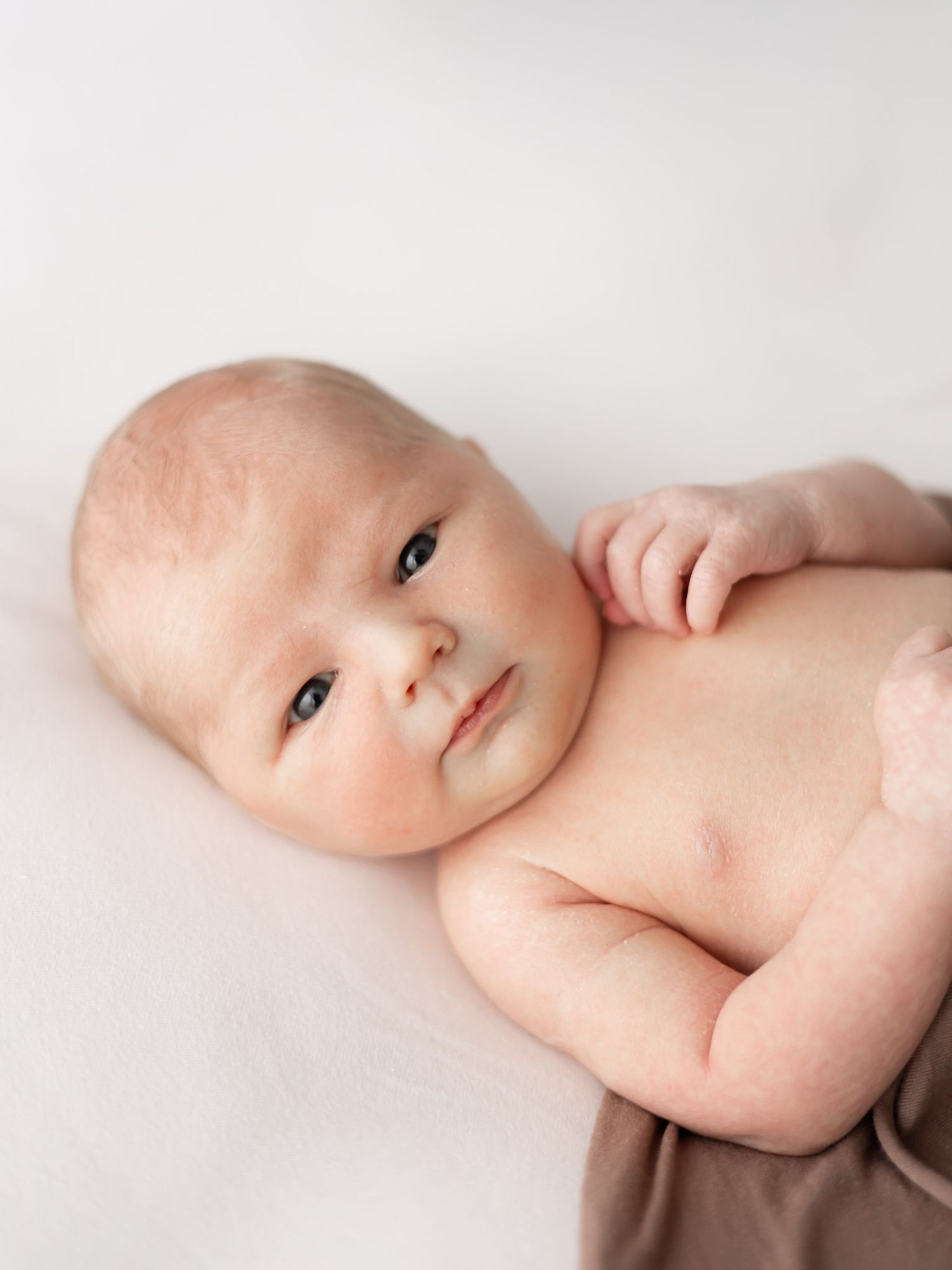 A series of close-up portraits showing a baby's gentle expressions against a soft white background.