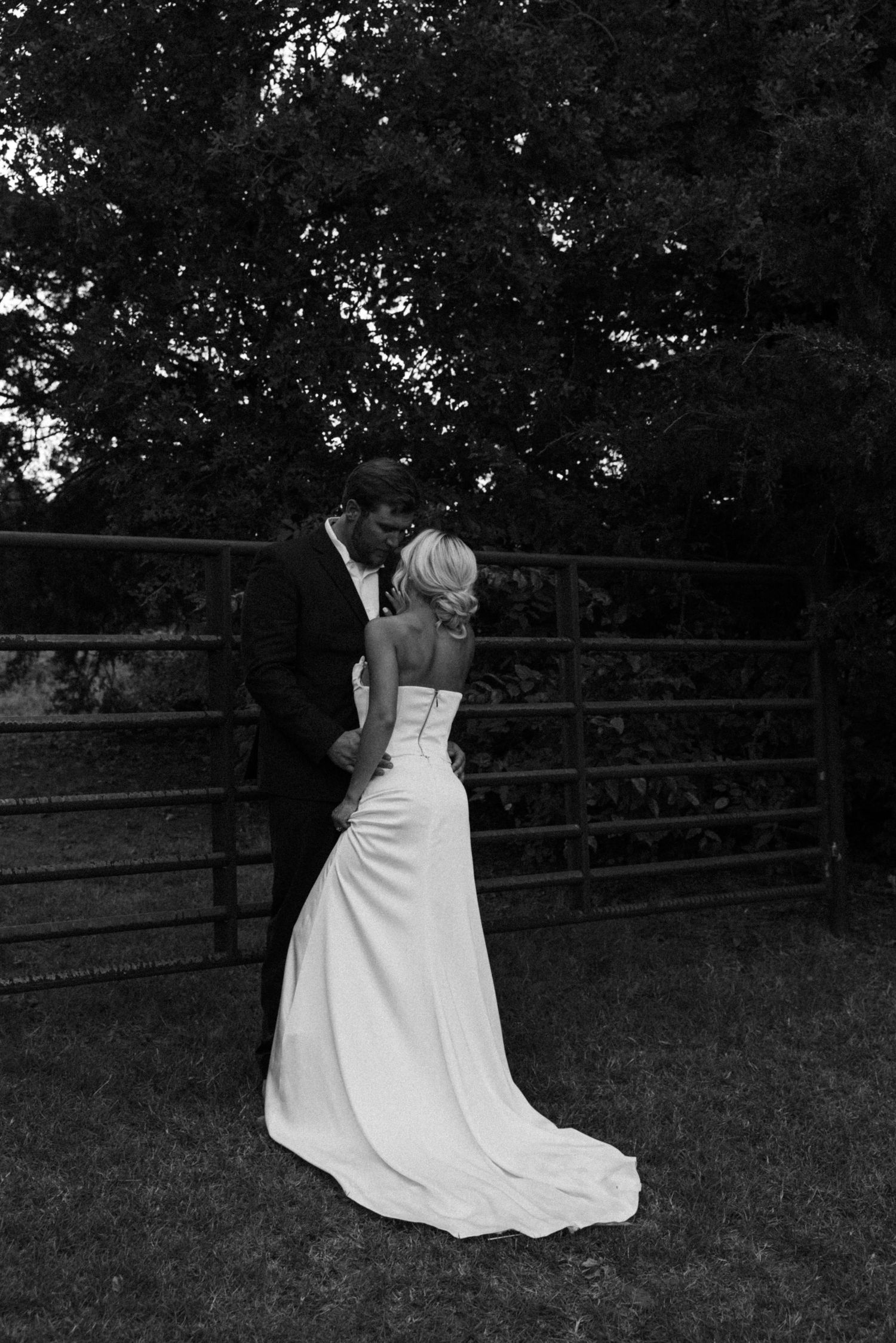 Black and white sequence of bride in flowing gown twirling in garden setting.