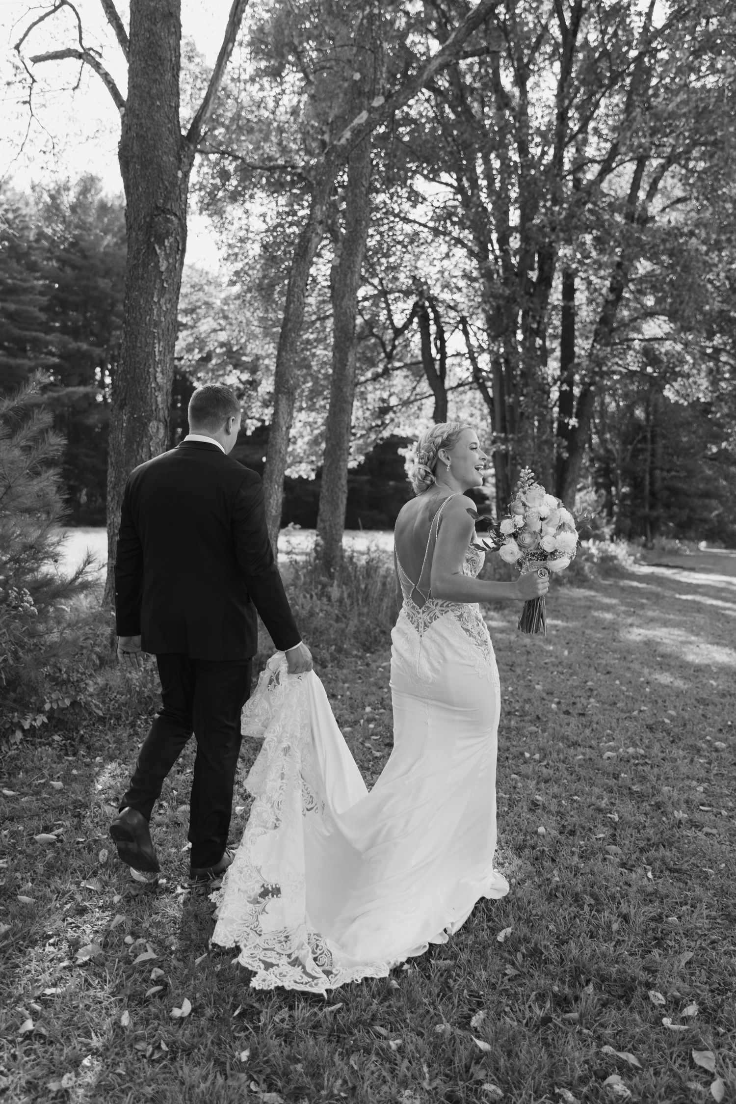 Black and white series of newlyweds walking through autumn leaves.
