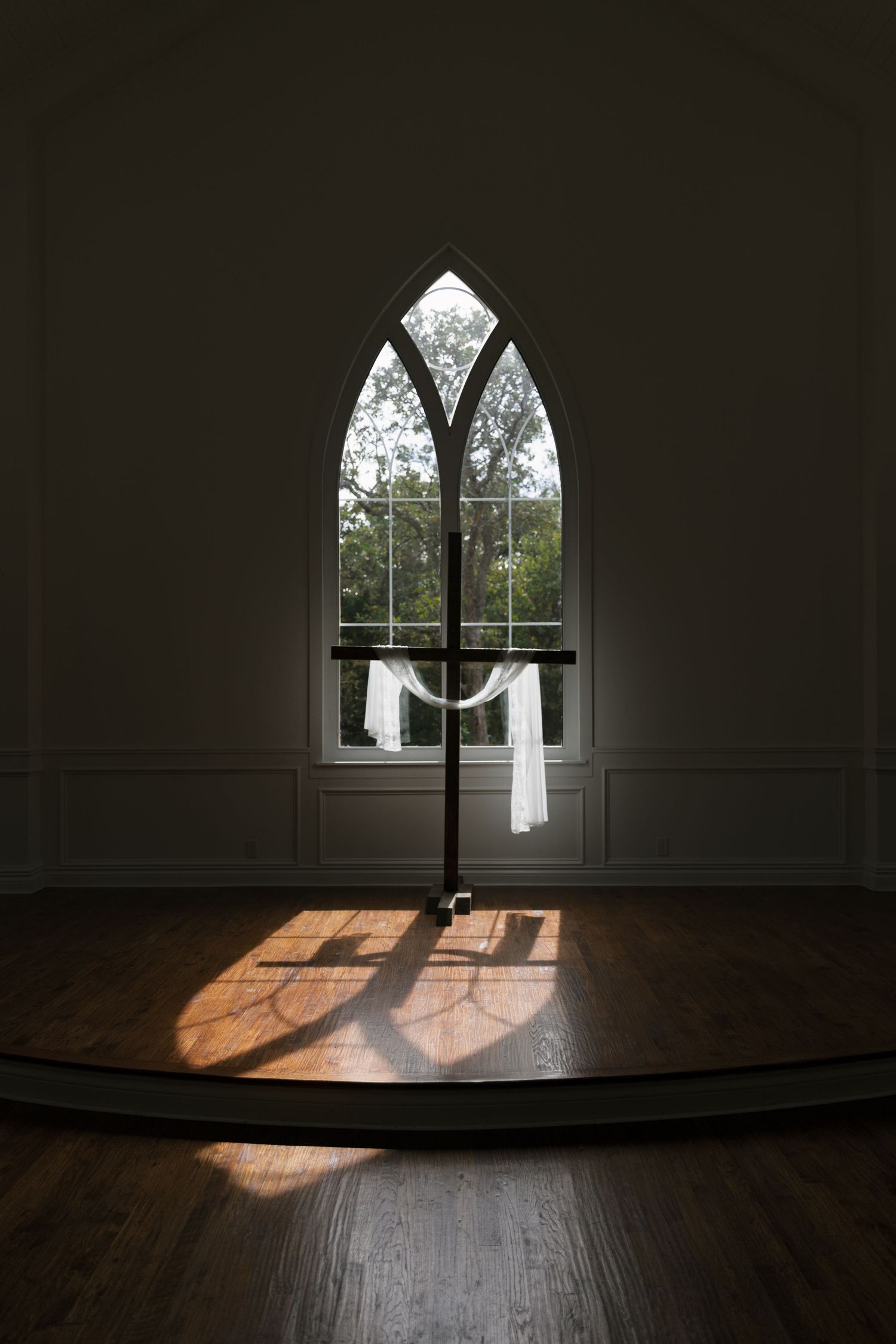 A series of dark interior photos showing sunlight and shadows cast through gothic windows onto wooden floors.