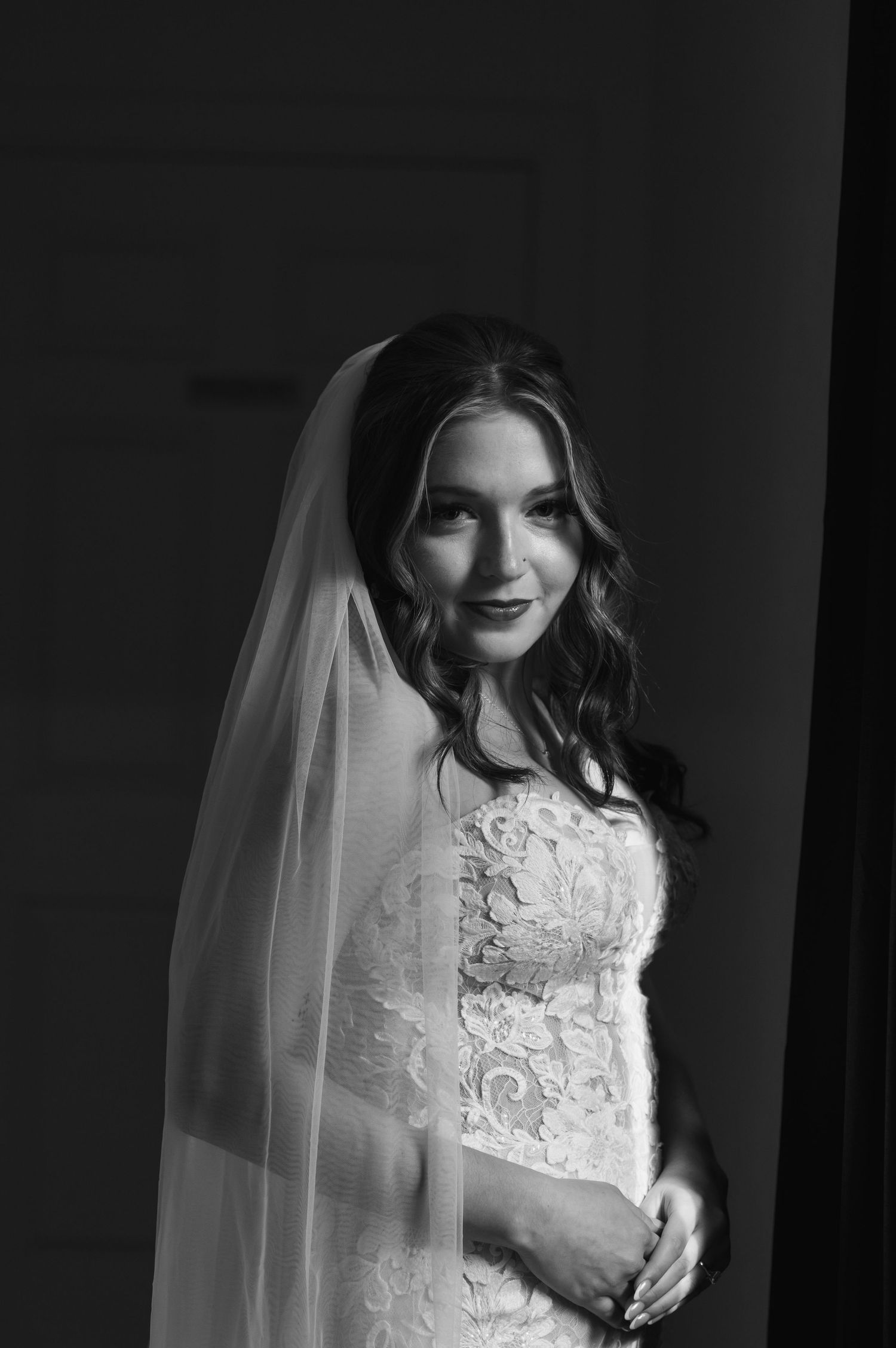 Dramatic black and white bridal portraits showcasing intricate lace details and flowing veil.