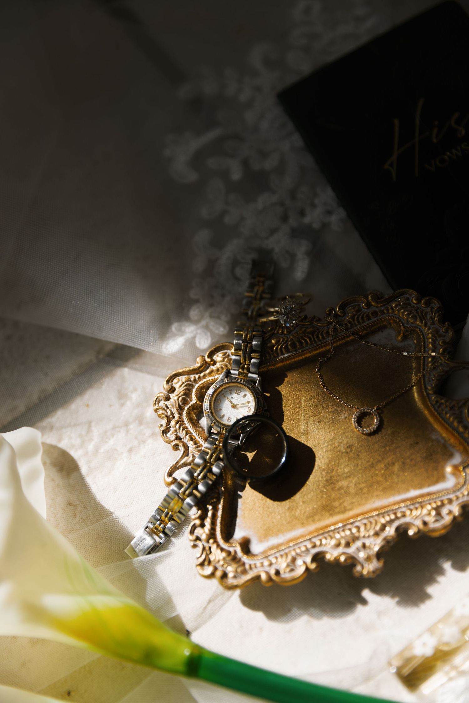 Ornate vintage brass keyhole plate with decorative scrollwork details captured in dramatic lighting against a white background.