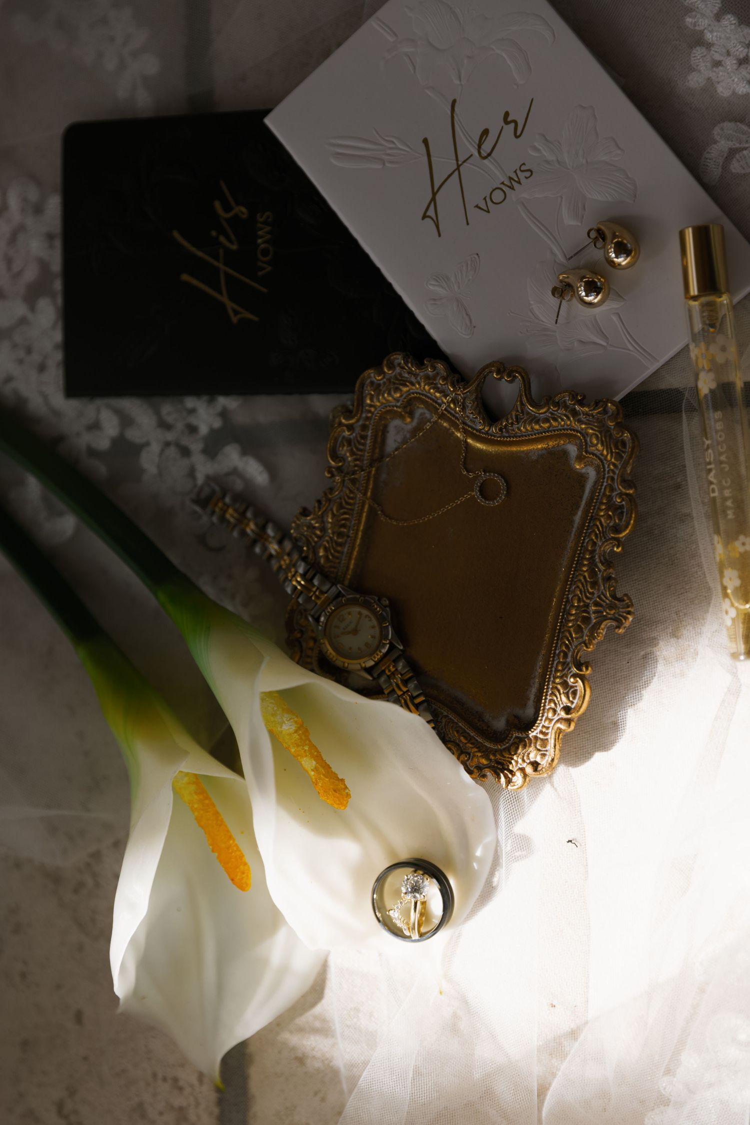 White lily flowers with golden ornate frames and decorative elements against a textured gray background.