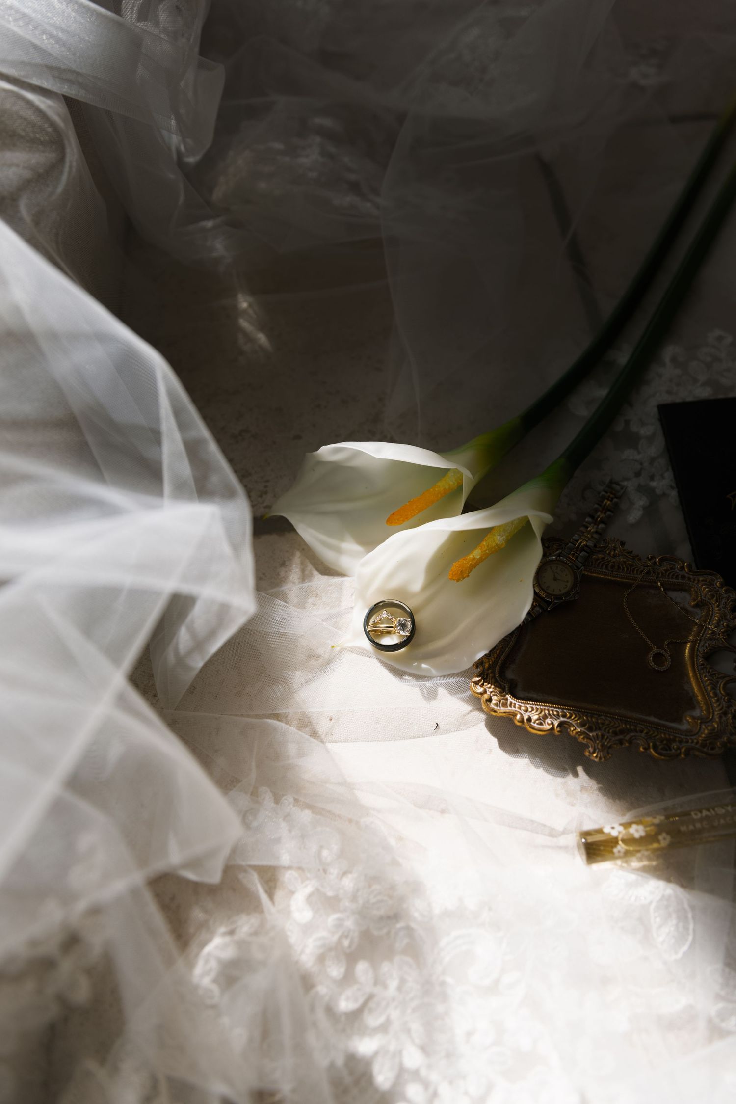 A dramatic close-up photo of a white calla lily flower emerging through ethereal smoke against a dark background.