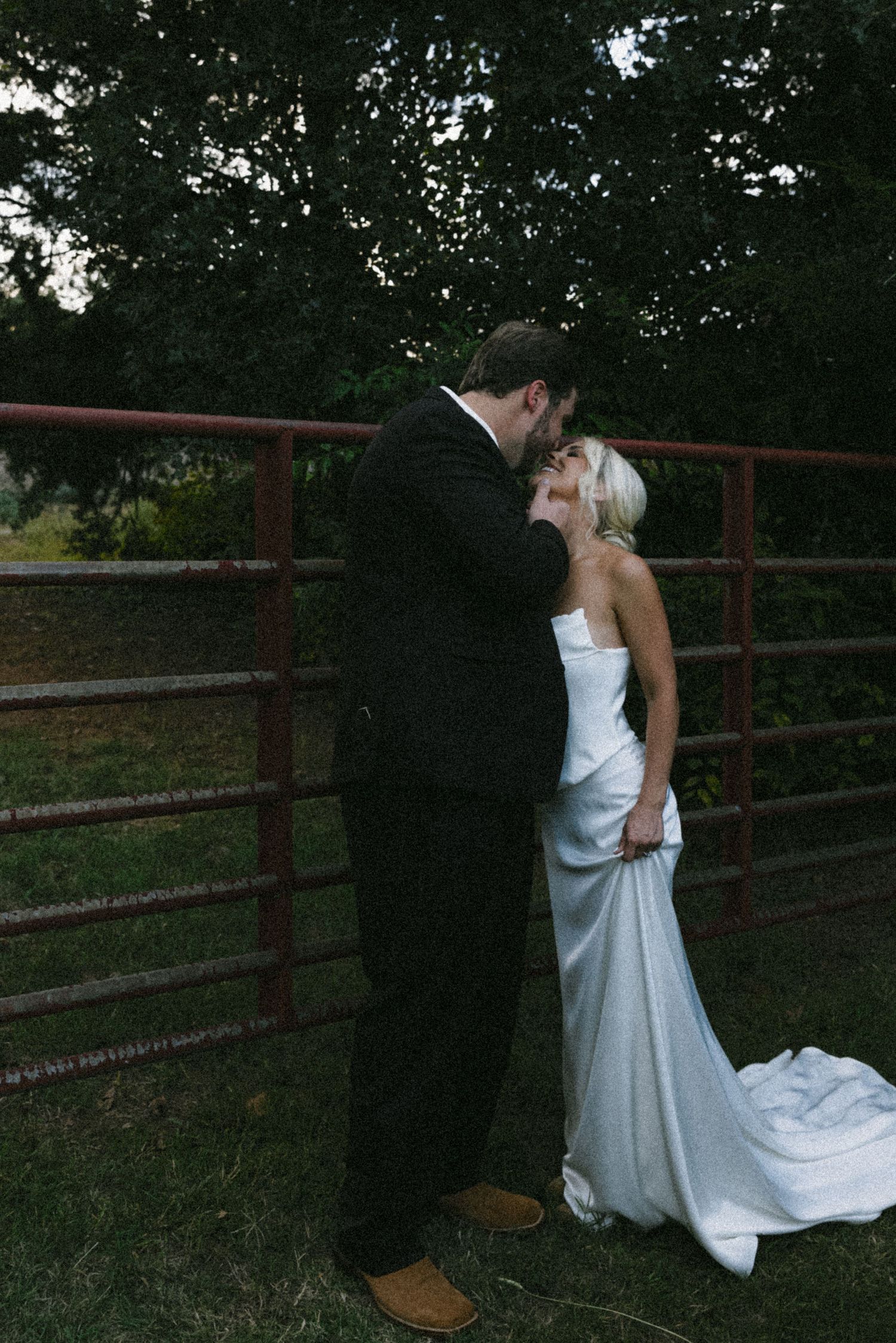 A romantic wedding photo series showing a couple embracing against a rustic fence at sunset.