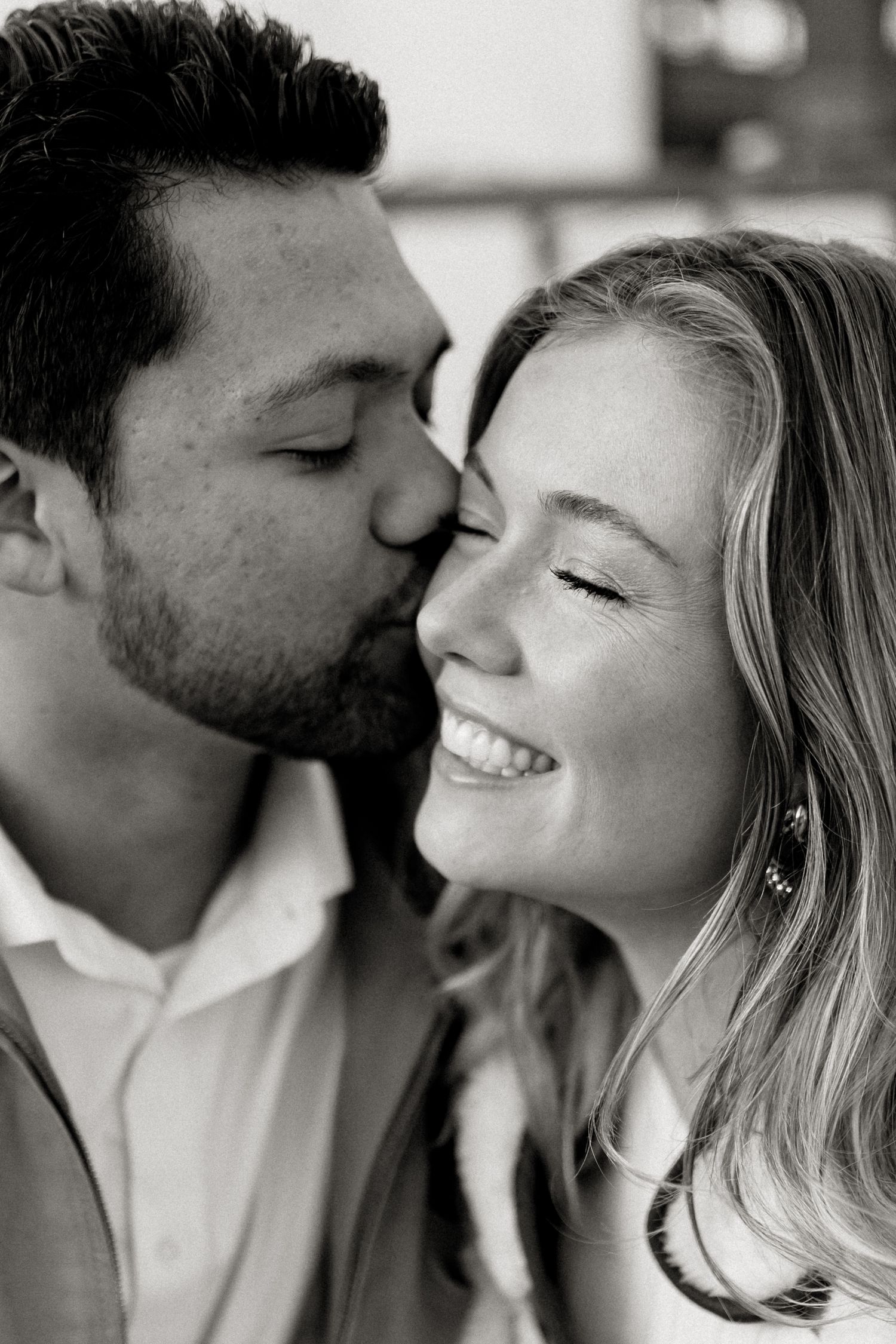black and white photography of a couple, the male is kissing her cheek and she is smiling. downtown grand junction couple