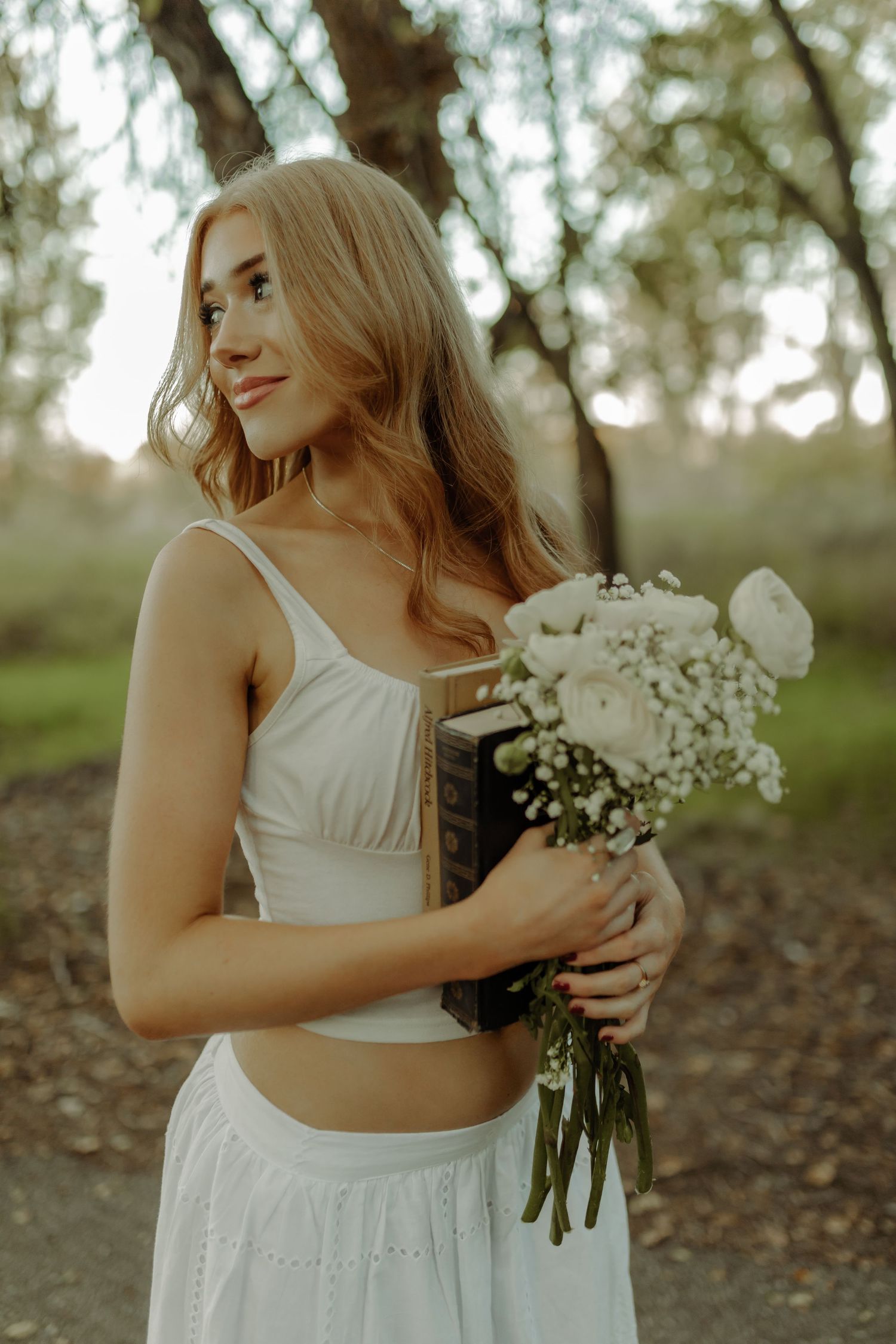grand junction colorado river trail photoshoot of beautiful girl smiling during senior session with flowers on a scenic trail