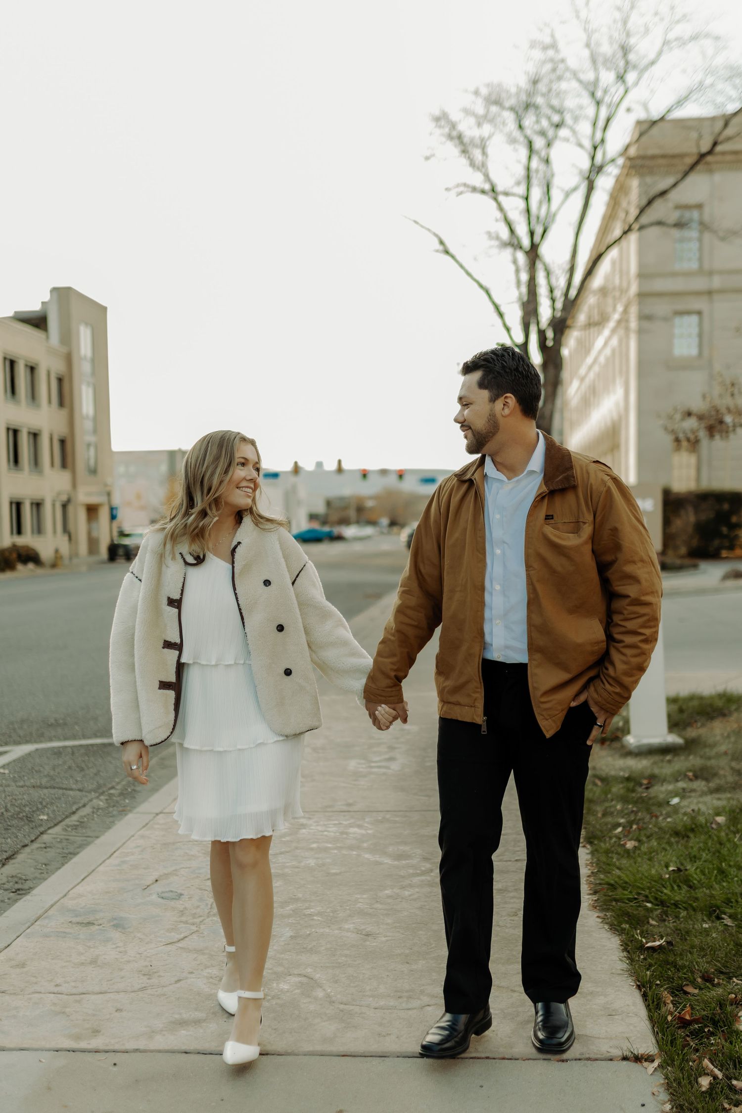 couple walking together and holding hands in  downtown grand junction engagement photography