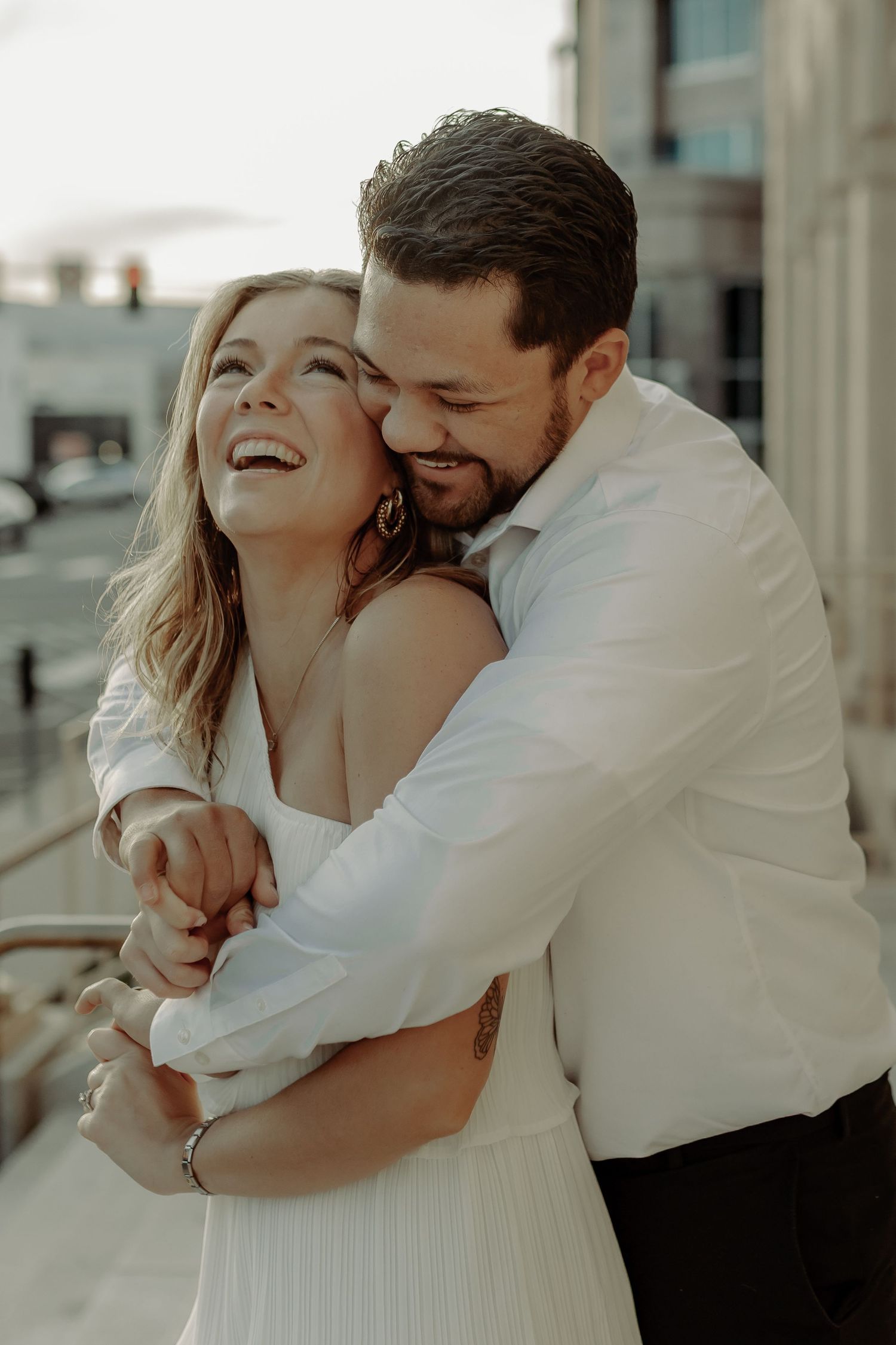 downtown grand junction photoshoot of couple smiling and hugging each other during  engagement  session