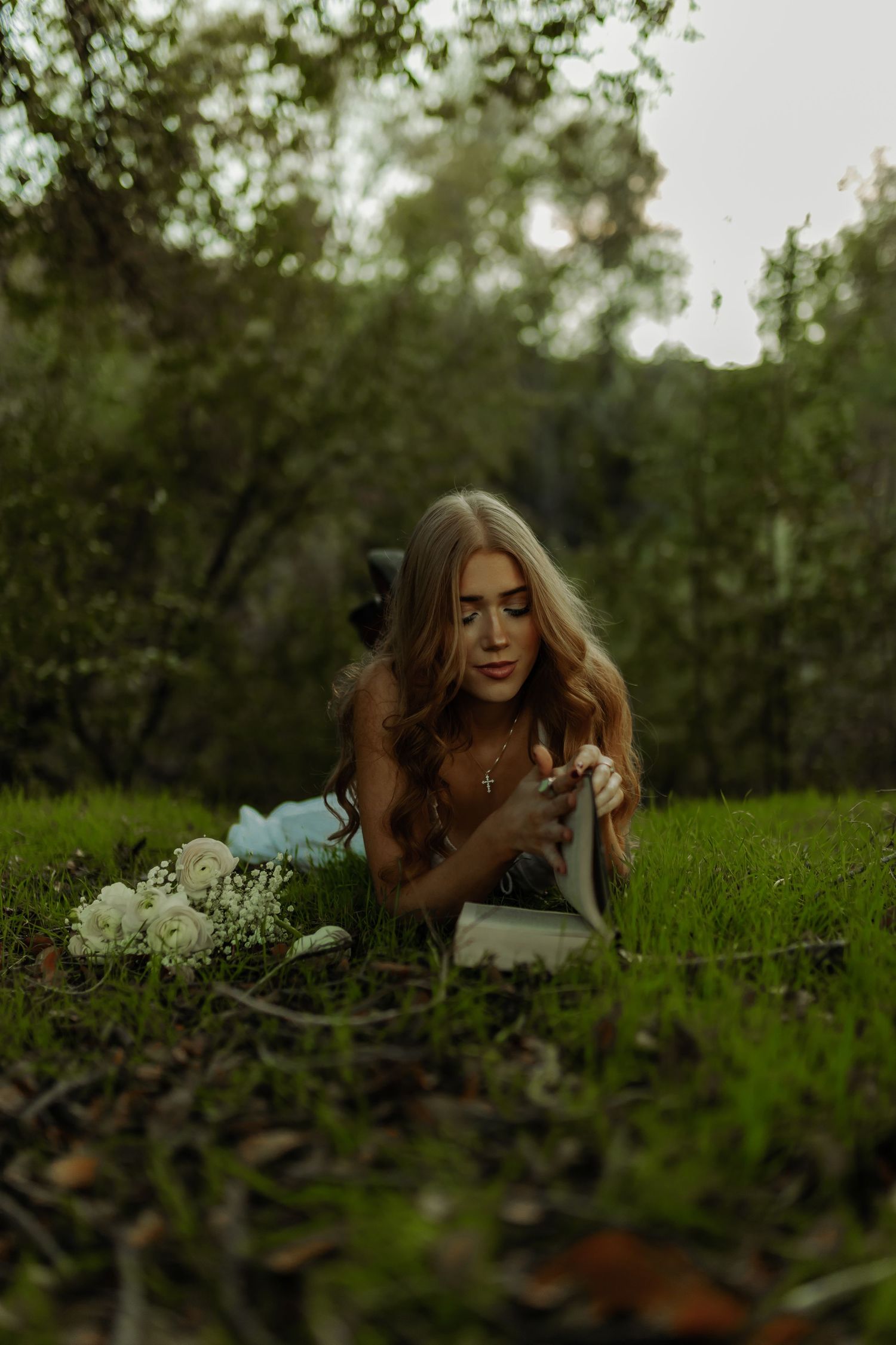 portrait photoshoot in grass of girl or senior photoshoot Grand Junction, CO reading a book with roses in stunning dress