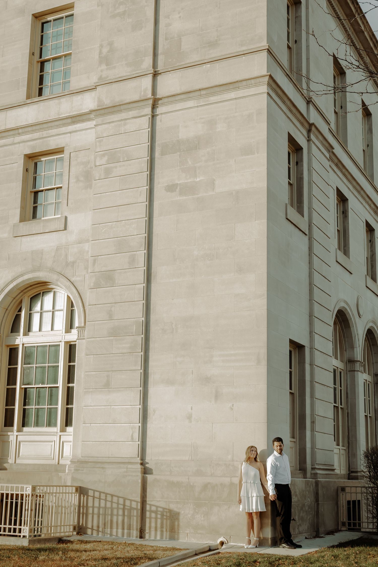 downtown grand junction courthouse photoshoot of couple standing and holding hands in a cinematic picture