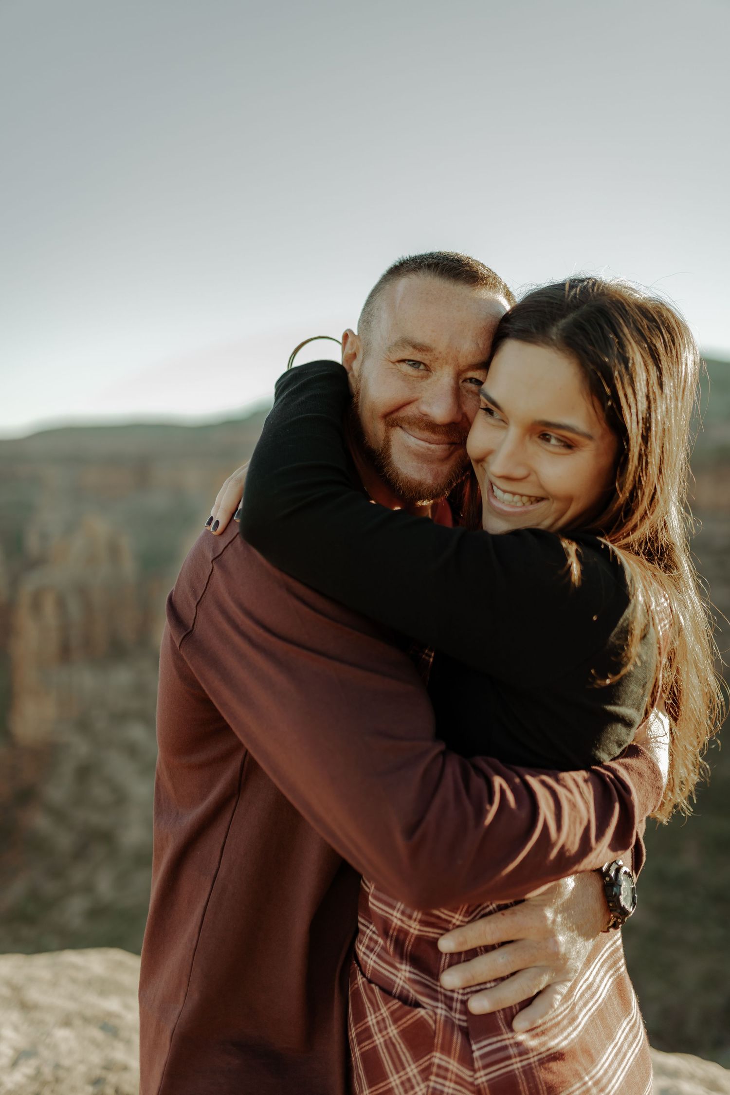 couple hugging on top of colorado national monument during engagement photoshoot